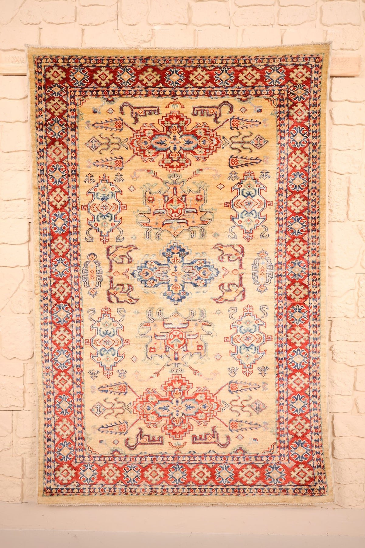 Tapis Kazak beige 137 × 103 cm, vue d'ensemble avec sa colonne de médaillons crochetés