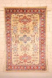 Tapis Kazak beige 137 × 103 cm, vue d'ensemble avec sa colonne de médaillons crochetés