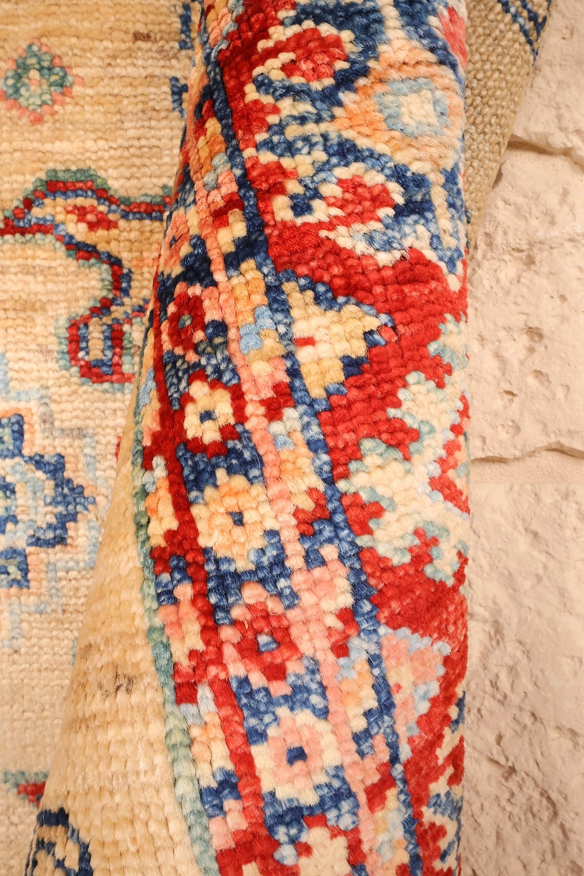Coin replié du tapis Kazak, épaisseur de la laine nouée main visible