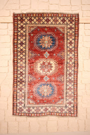 Tapis Kazak rouge 138 × 89 cm, vue d'ensemble aux trois médaillons crantés