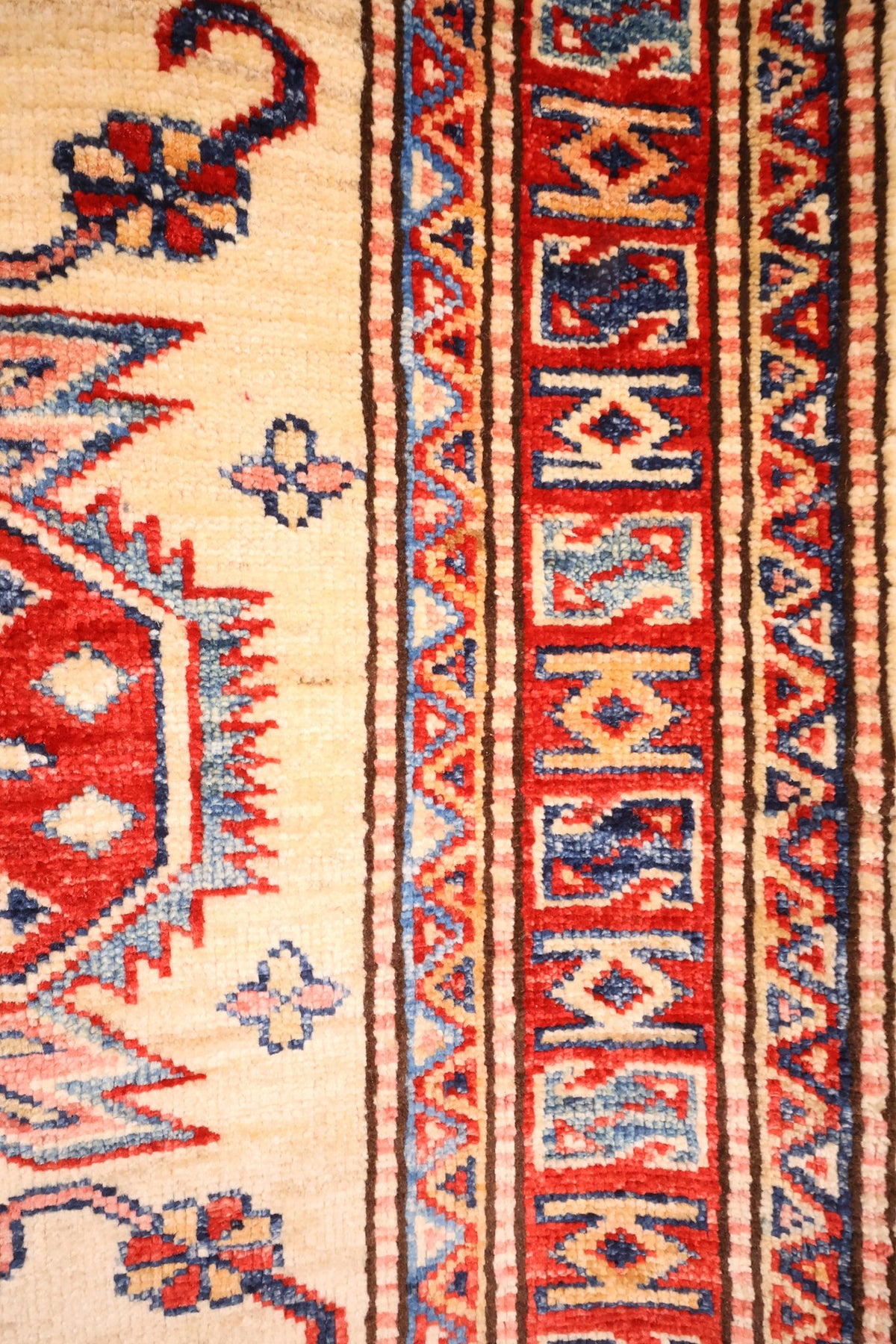 Bordure rouge à cartouches et contre-bordures dentées du tapis Kazak noué main