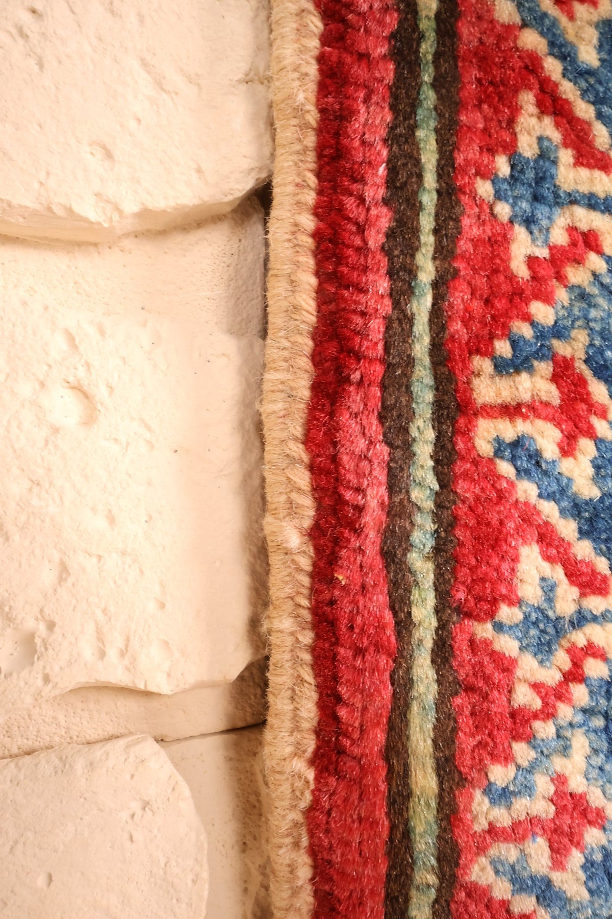 Lisière du tapis Kazak rouge et beige, finition latérale en laine