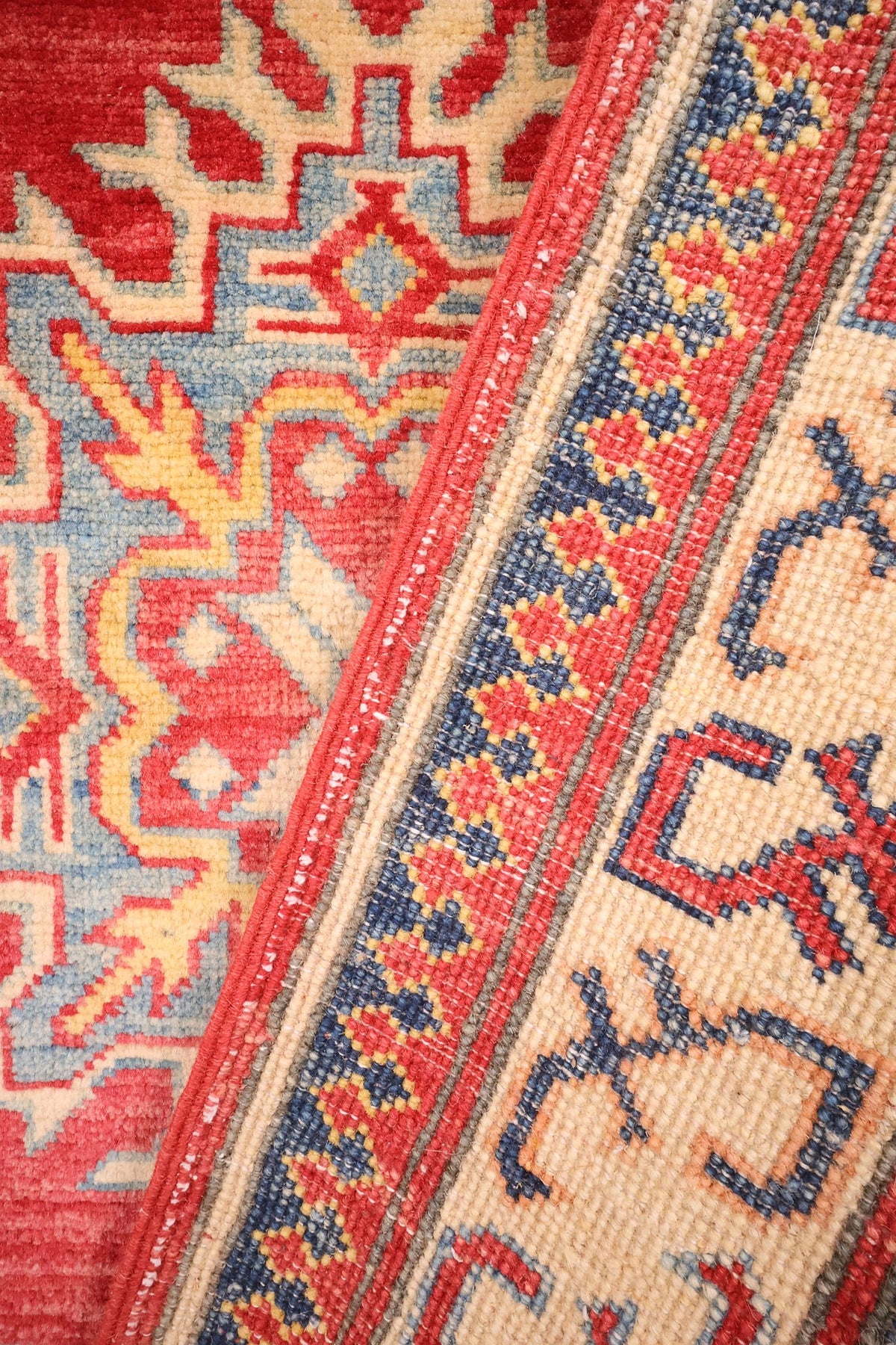 Coin replié du tapis Kazak en laine, contre-bordures à dents de scie