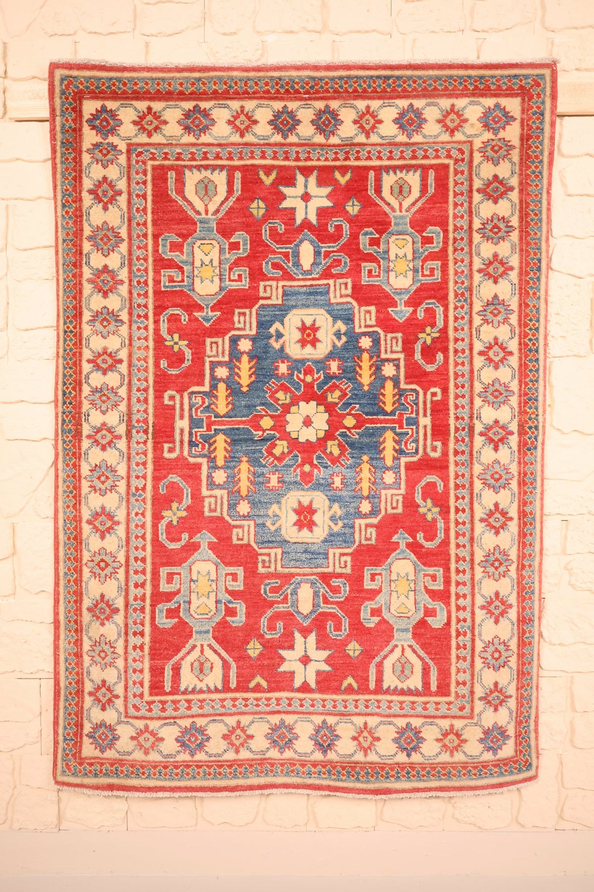 Tapis Kazak rouge 150 × 103 cm, vue d'ensemble du médaillon central bleu