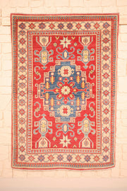 Tapis Kazak rouge 150 × 103 cm, vue d'ensemble du médaillon central bleu