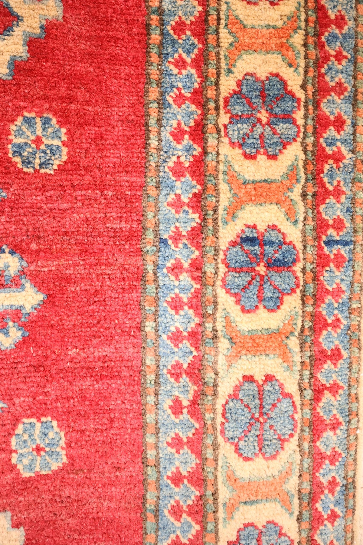 Bordure ivoire à rosettes bleues et contre-bordures à crochets, tapis Kazak