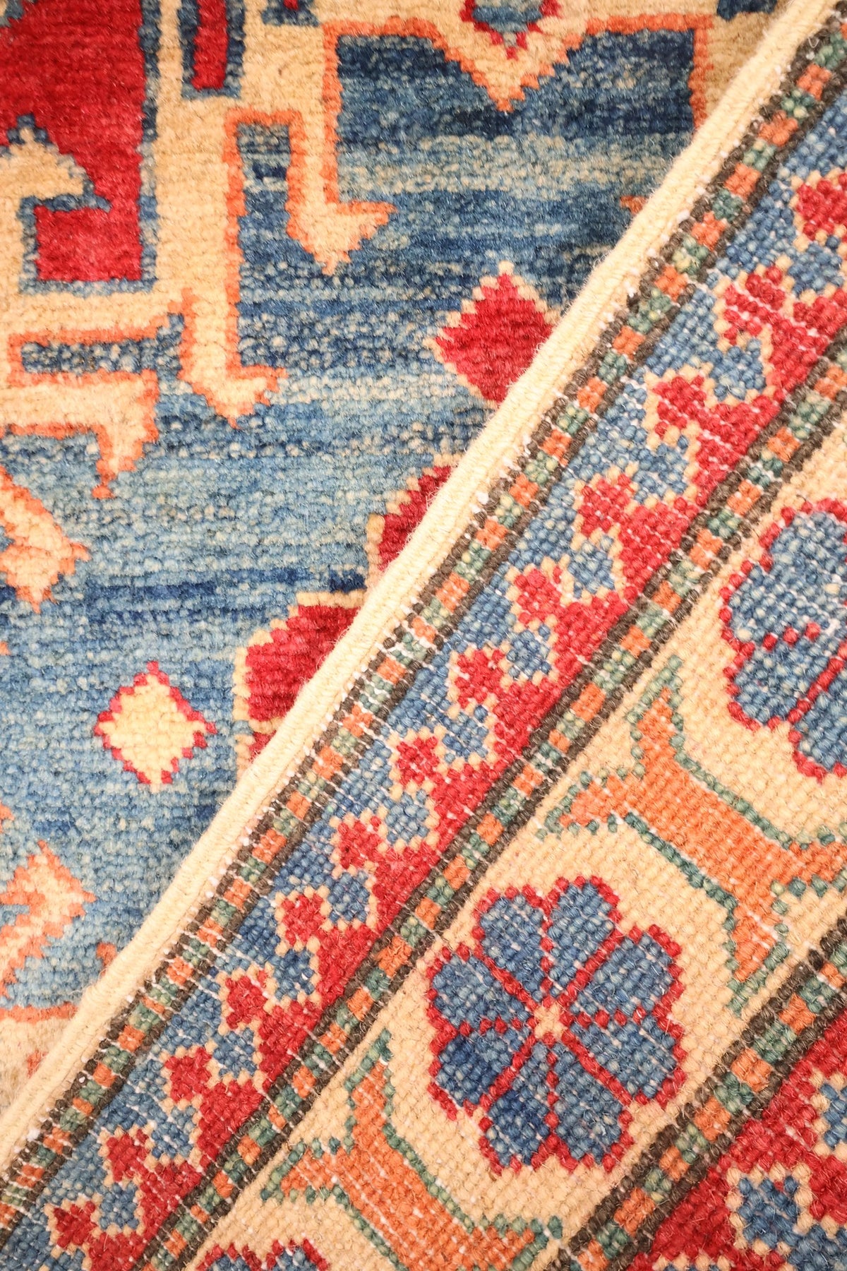 Coin replié du tapis Kazak rouge et bleu, laine nouée à la main