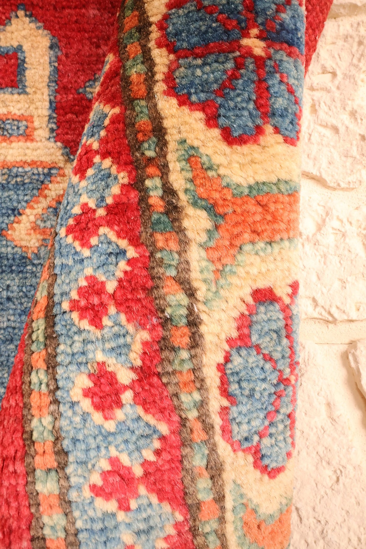 Lisière du tapis Kazak, bandes beige, orange et bleu en relief