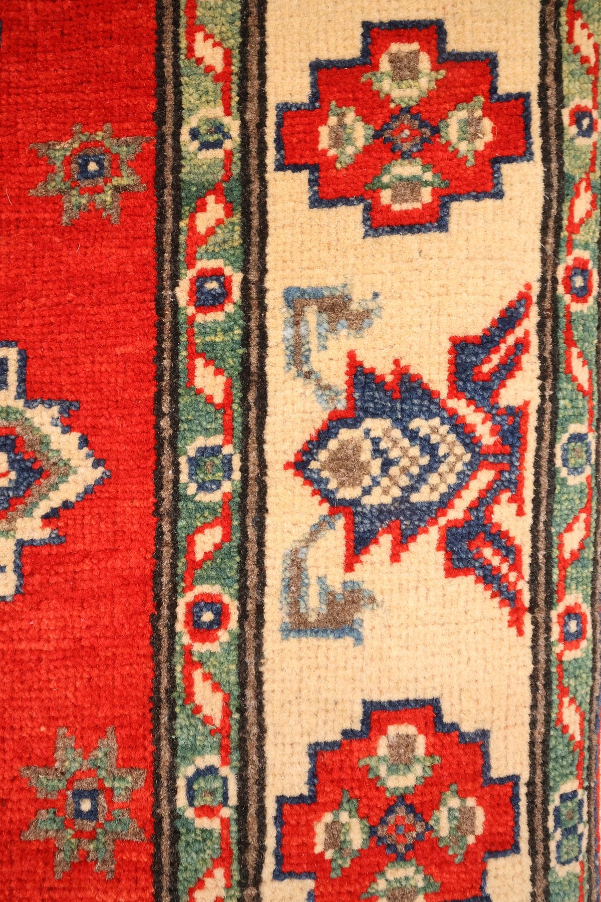 Bordure ivoire à croix rouges et palmettes bleues, contre-bordures vertes à rinceaux