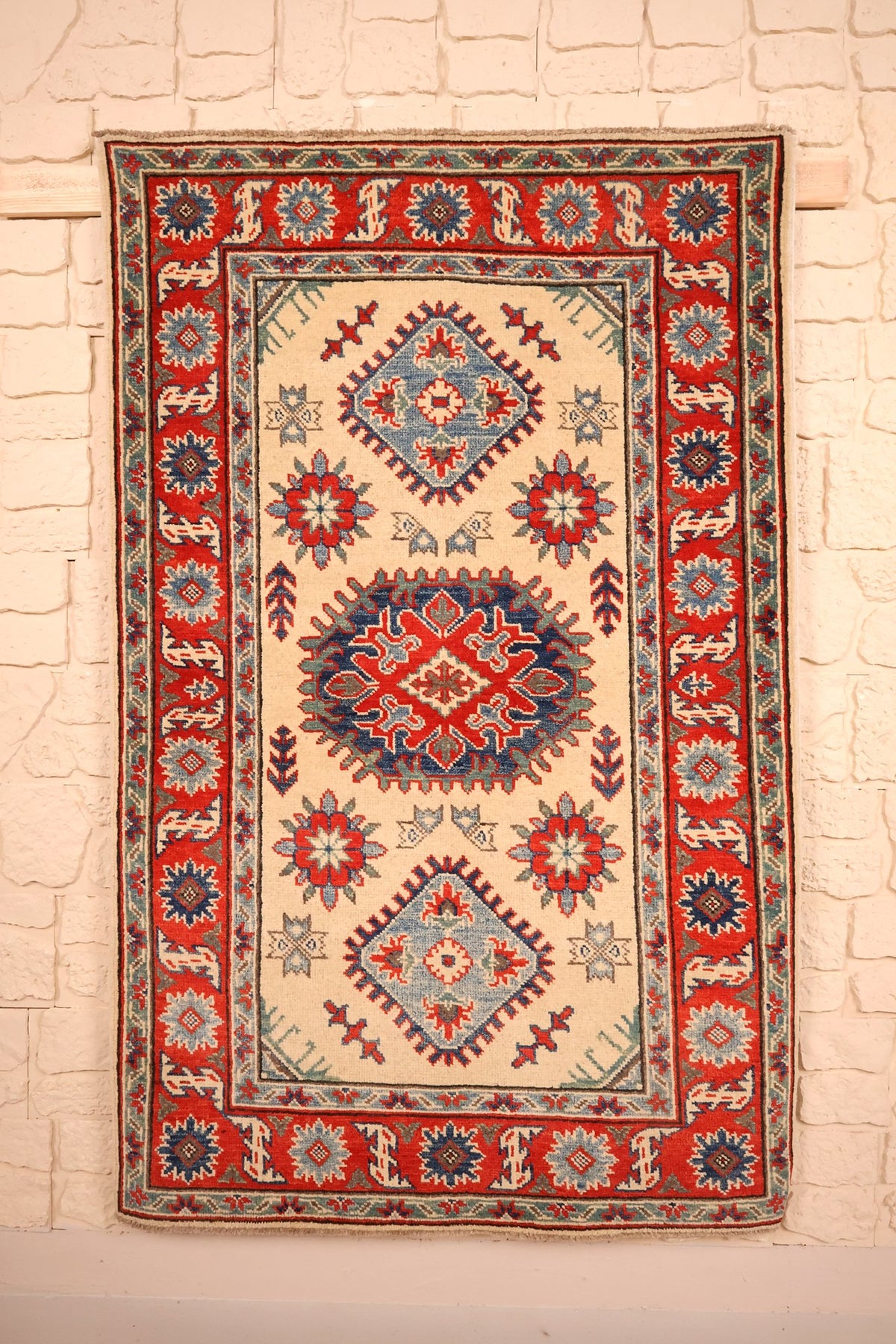 Tapis Kazak beige 157 × 99 cm, vue d'ensemble du médaillon central rouge et bleu