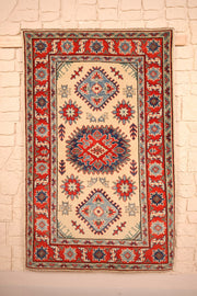 Tapis Kazak beige 157 × 99 cm, vue d'ensemble du médaillon central rouge et bleu