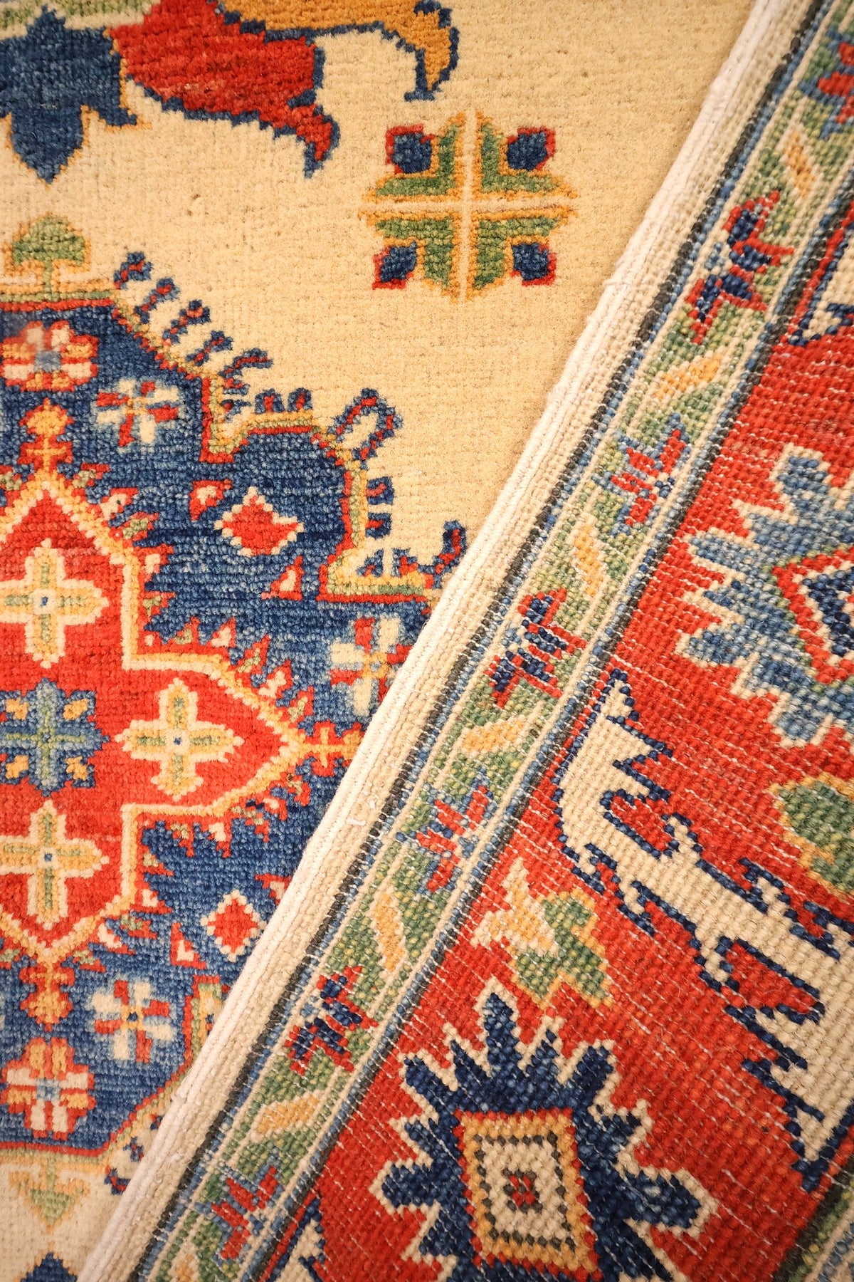 Envers du tapis Kazak beige, nœuds visibles au revers de la bordure rouge