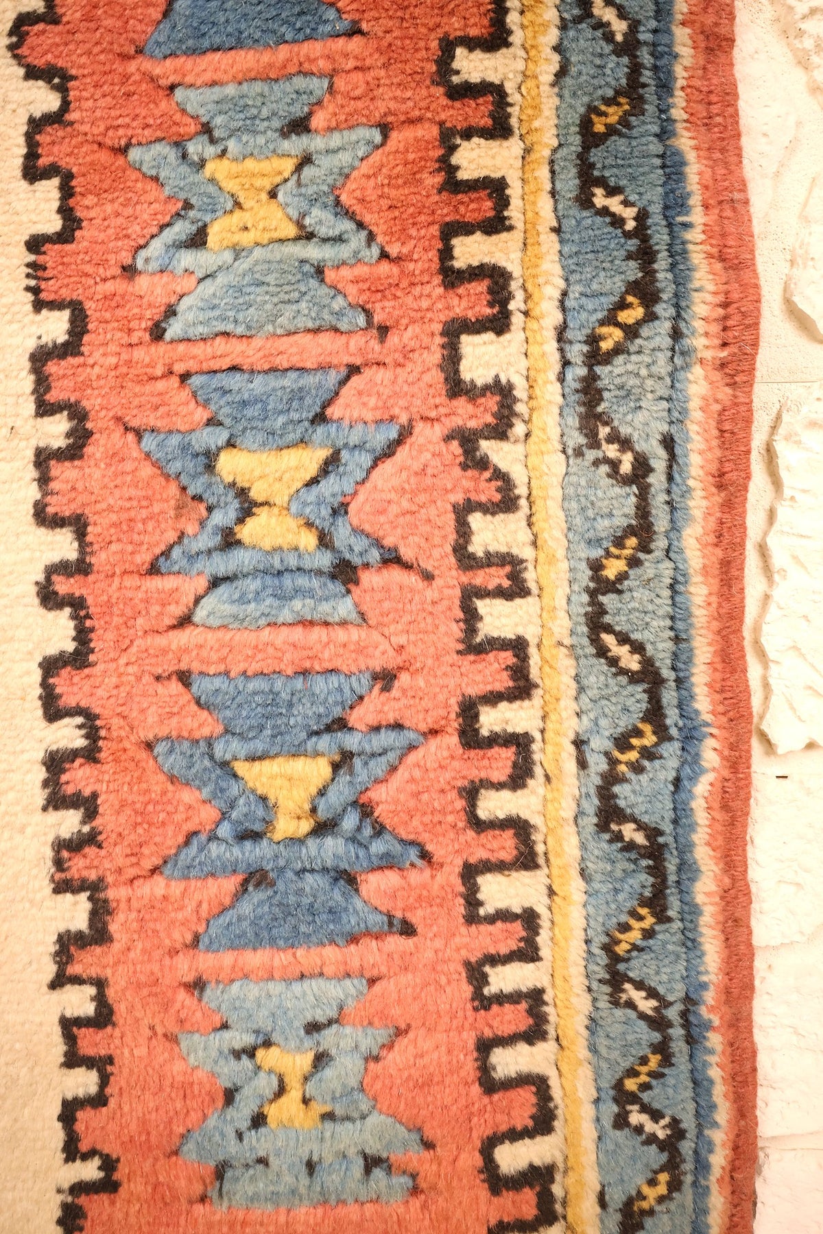 Bordure rouge à sabliers bleu et jaune du tapis Konya, contre-bordure bleue à rinceaux