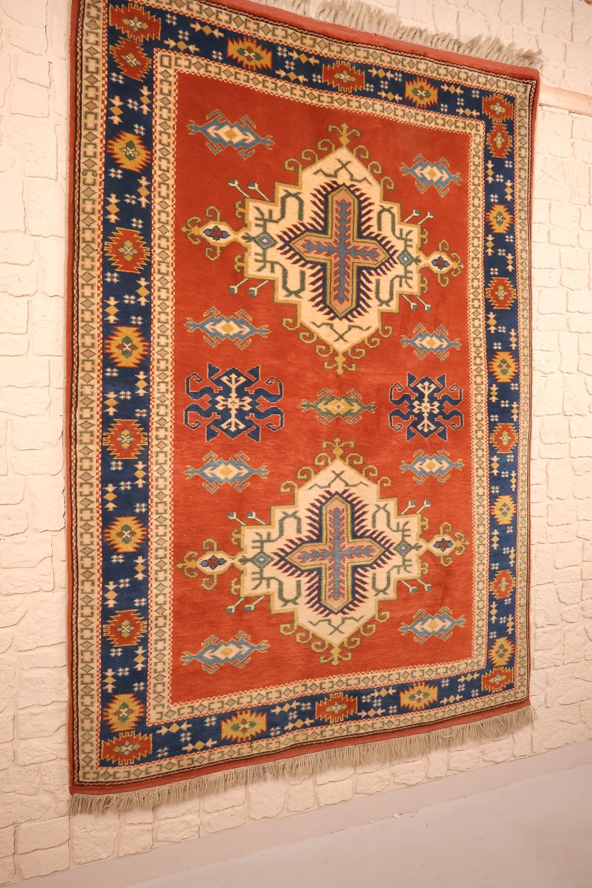 Tapis Konya en laine noué main, vue de biais sur le champ rouge brique