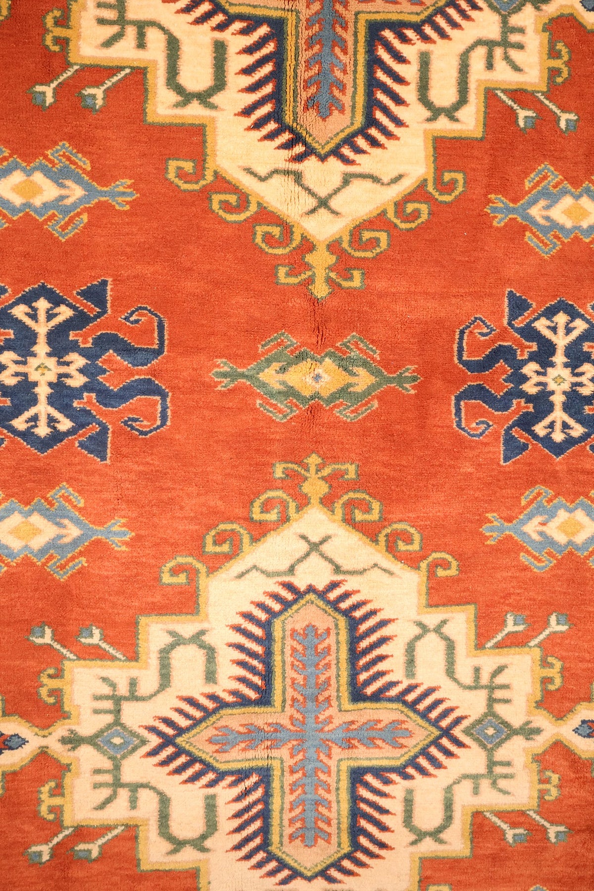 Détail des médaillons crénelés ivoire à croix bleue du tapis Konya rouge