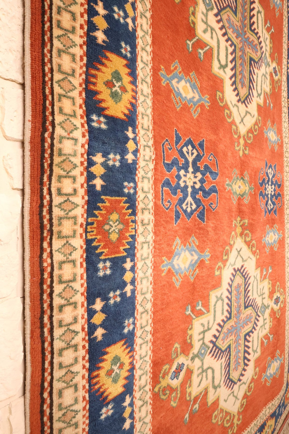 Motifs bleu foncé à crochets et étoiles semées sur le champ du tapis Konya
