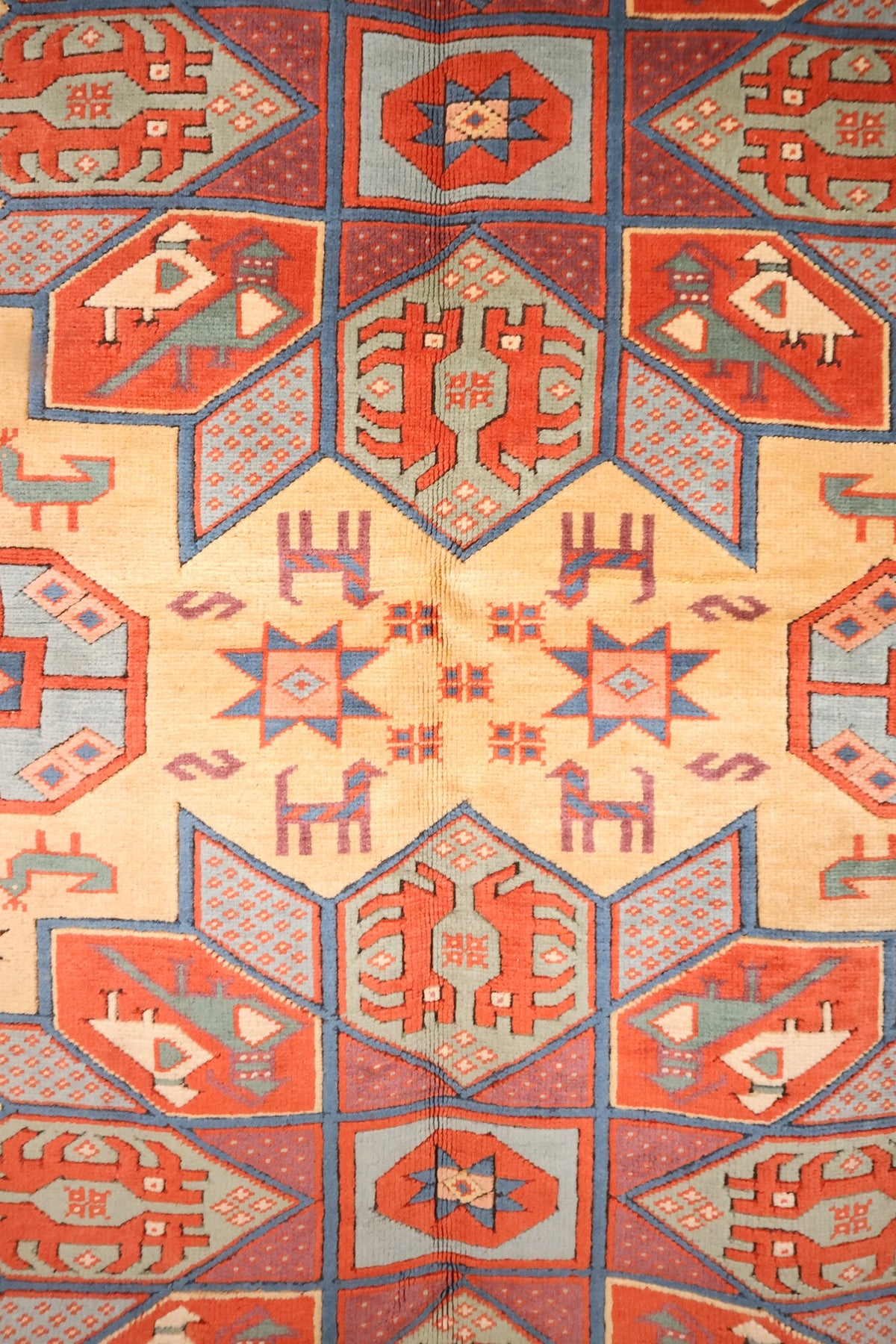 Détail du tapis Konya : étoiles à huit branches, oiseaux et quadrupèdes stylisés