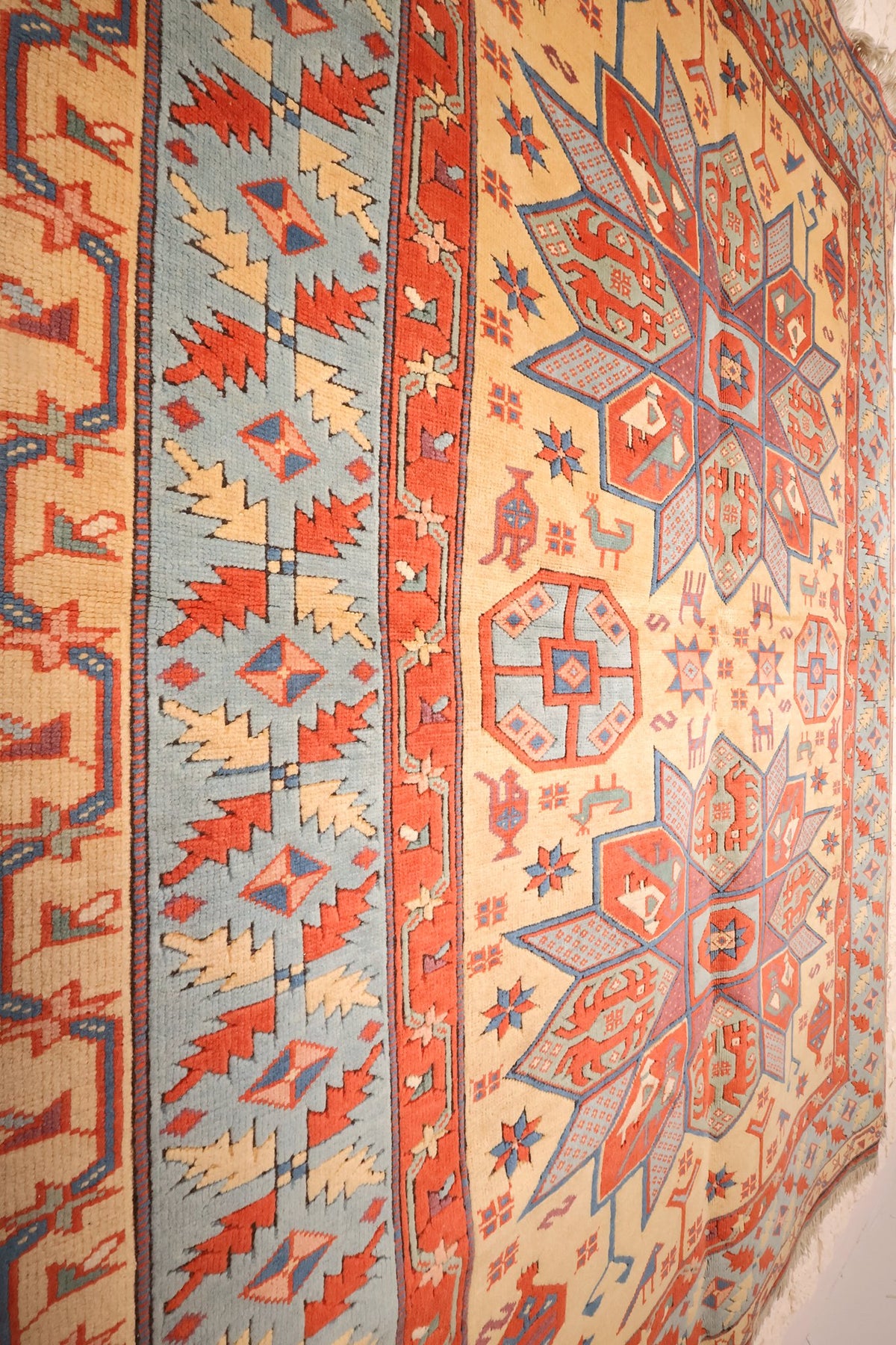 Contre-bordures rouges et champ beige du tapis Konya 237 × 183 cm, vue oblique