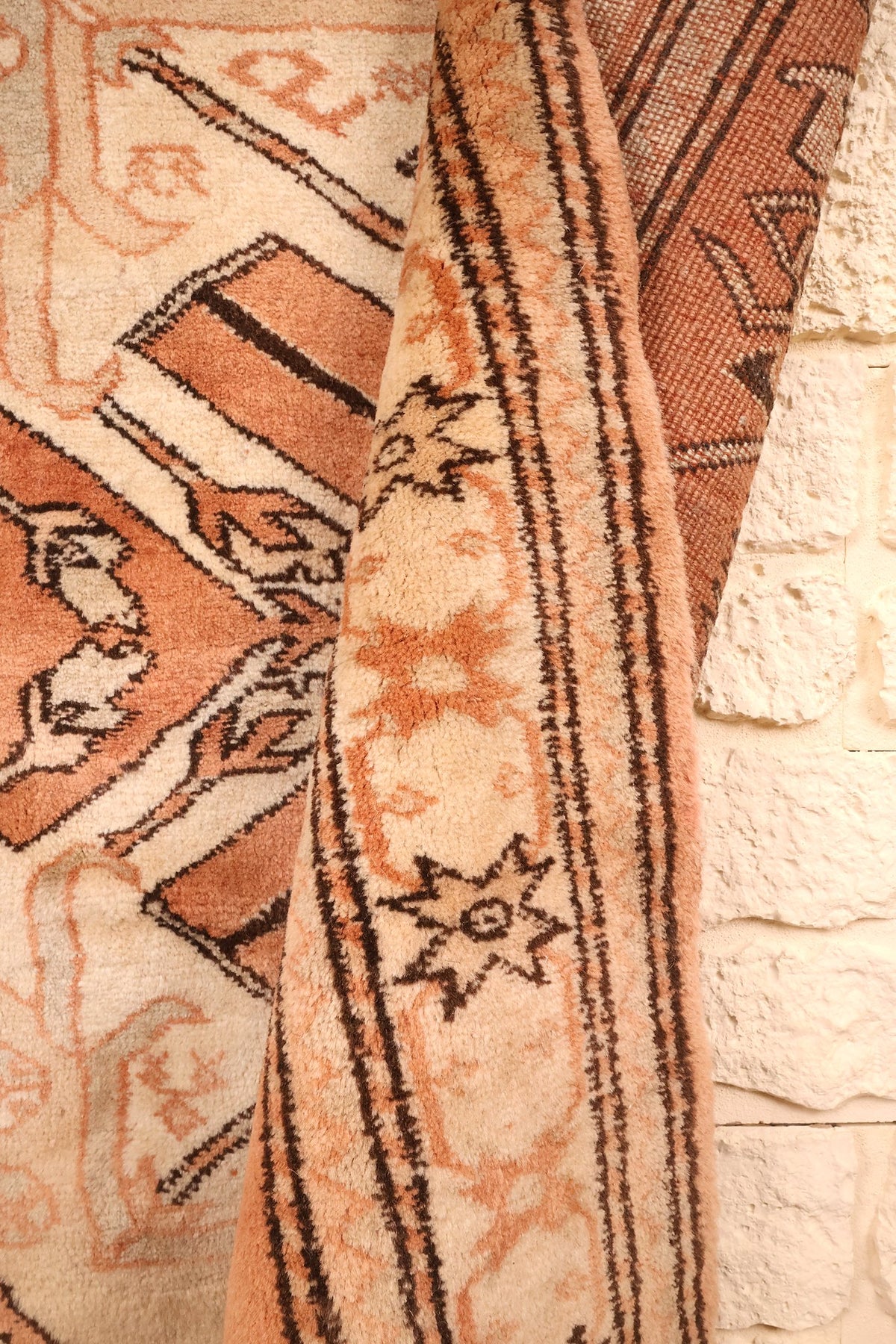 Lisière du tapis Kula orange et marron, repli montrant l'épaisseur du tissage