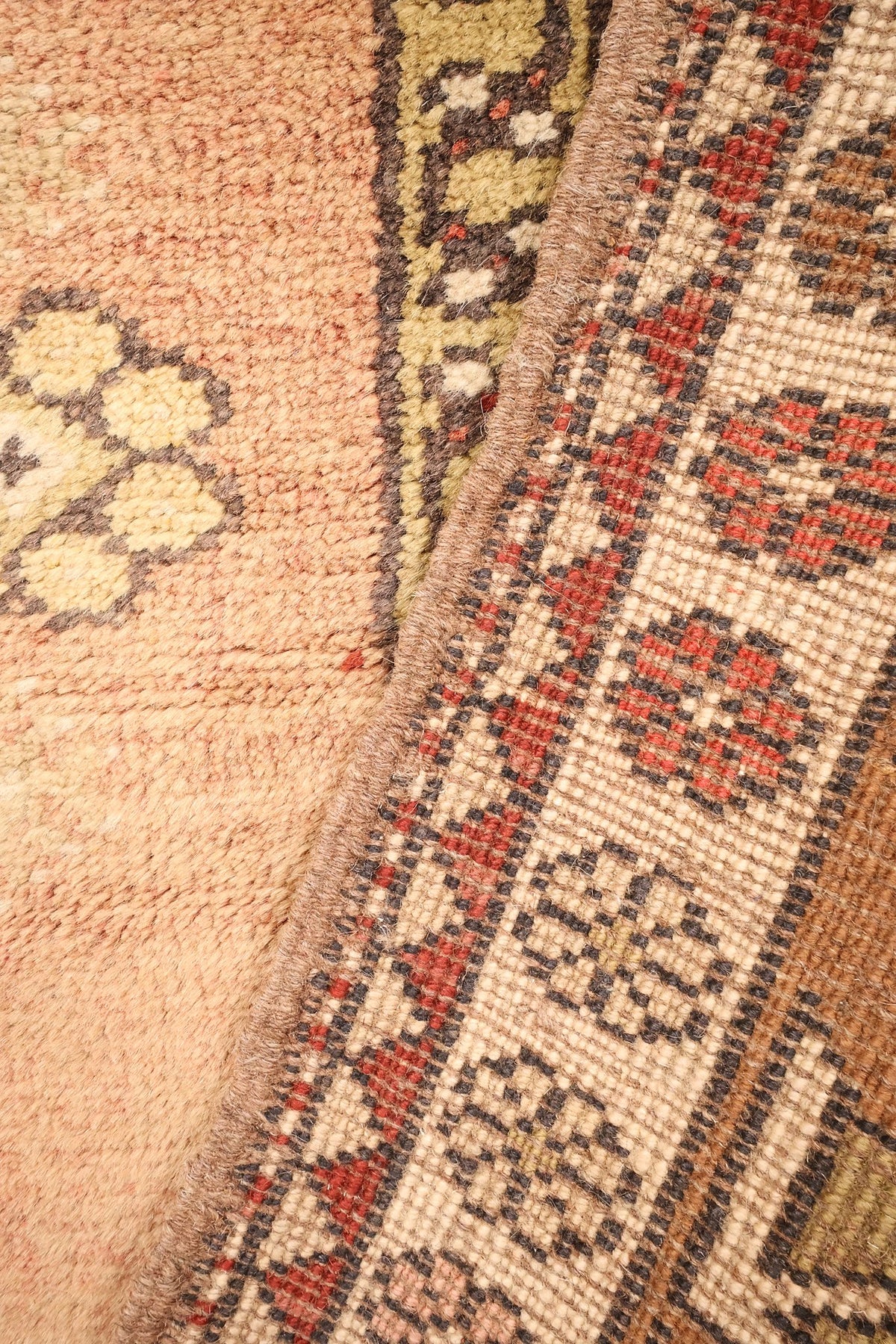 Coin du tapis Melas rose et beige, galon vert pâle entre champ et contre-bordure
