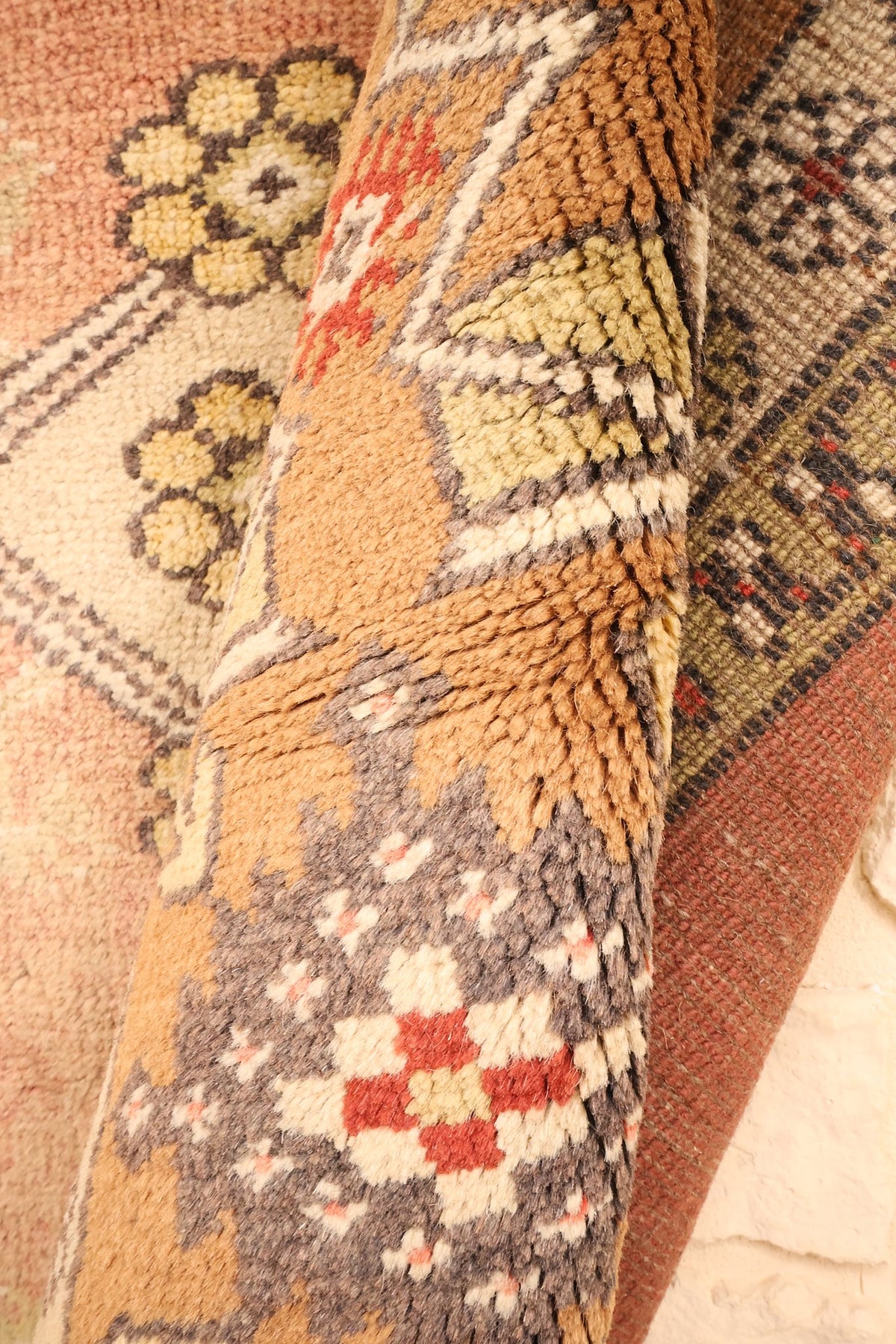 Coin replié du tapis Melas en laine, épaisseur et motifs de bordure visibles