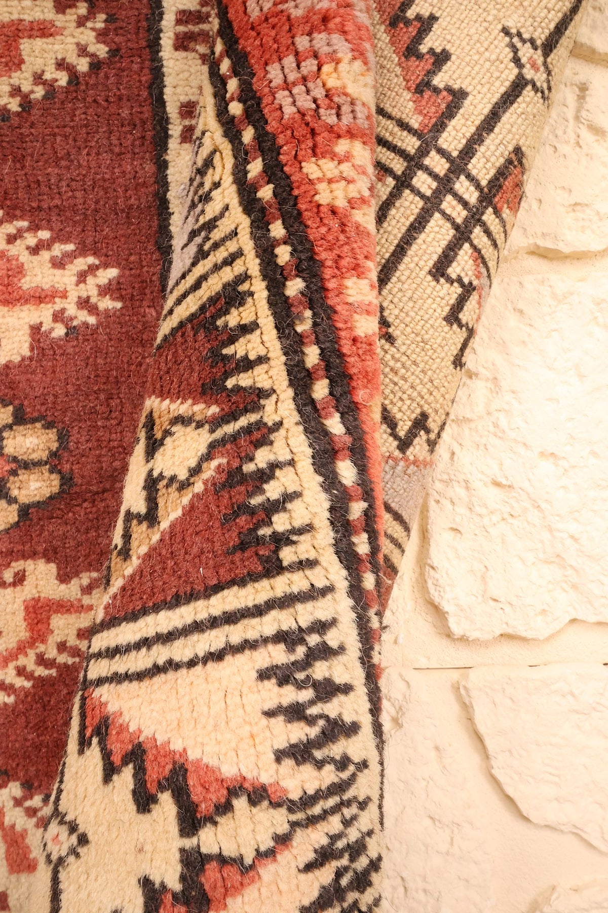 Angle retourné du tapis Melas 210 × 110 cm, envers en laine et bordure dentelée