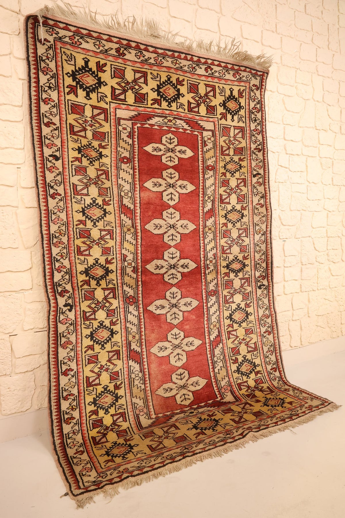 Tapis Melas en laine noué à la main, vue de biais montrant les bordures beiges