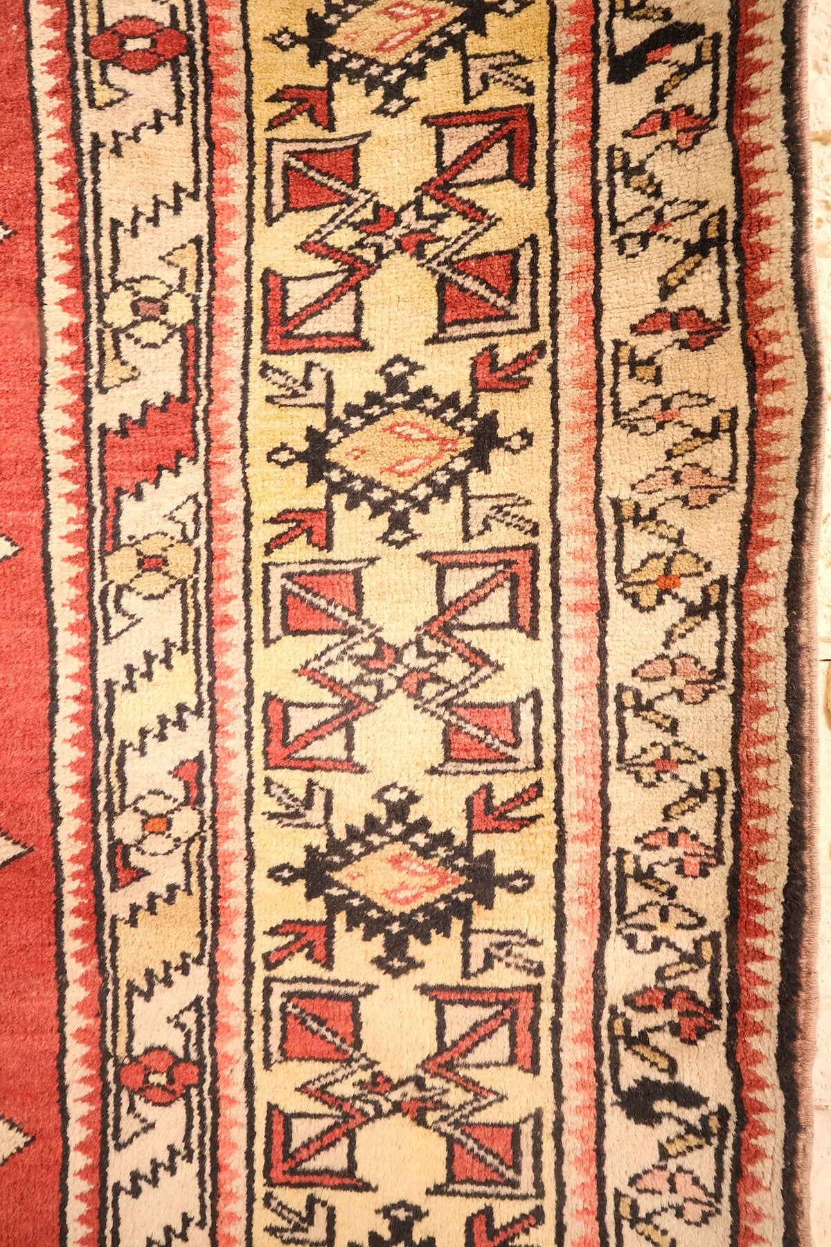 Bordures jaune paille du tapis Melas, étoiles, losanges crochetés et carrés rouges