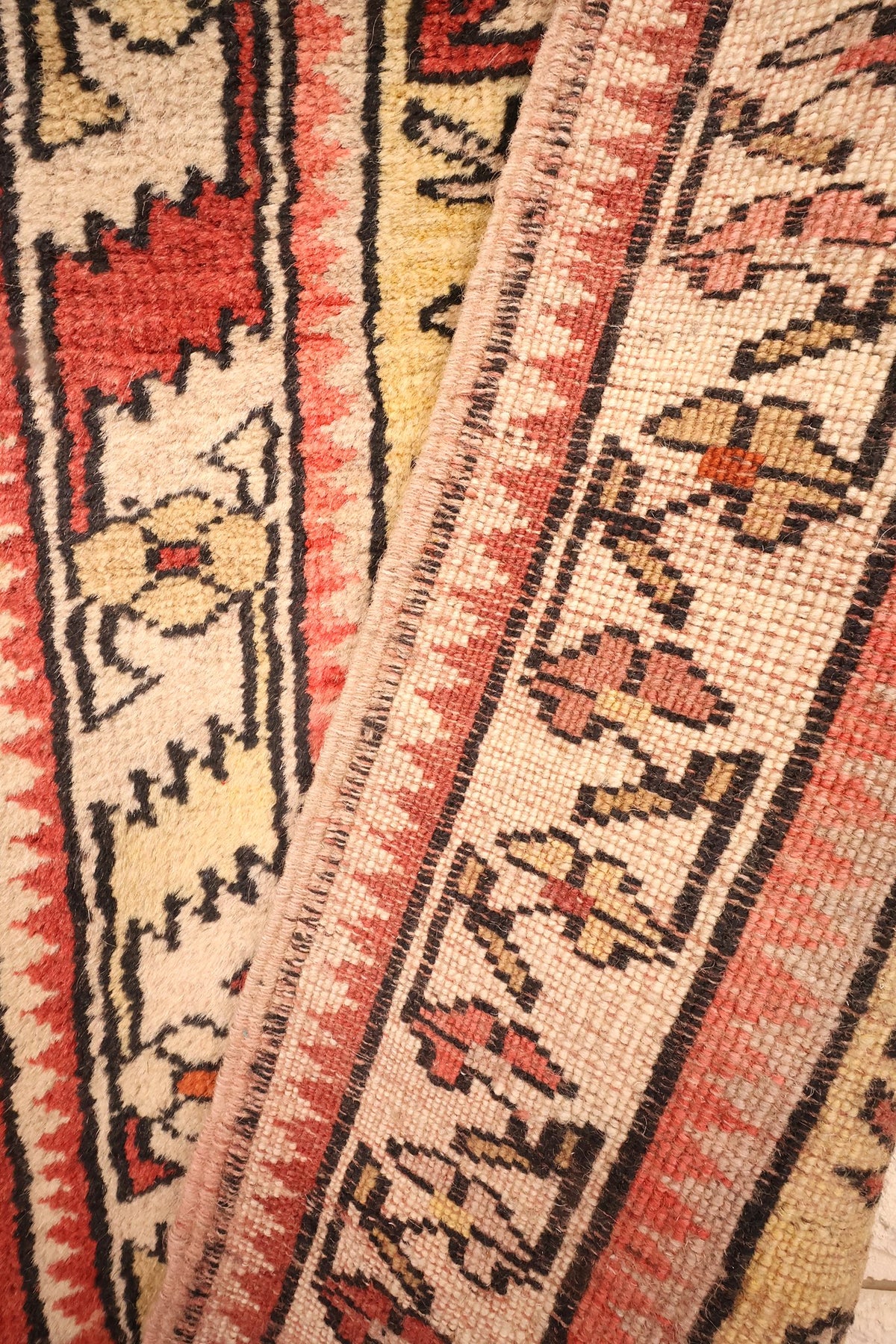 Coin replié du tapis Melas, lignes noires en zigzag et envers noué visible