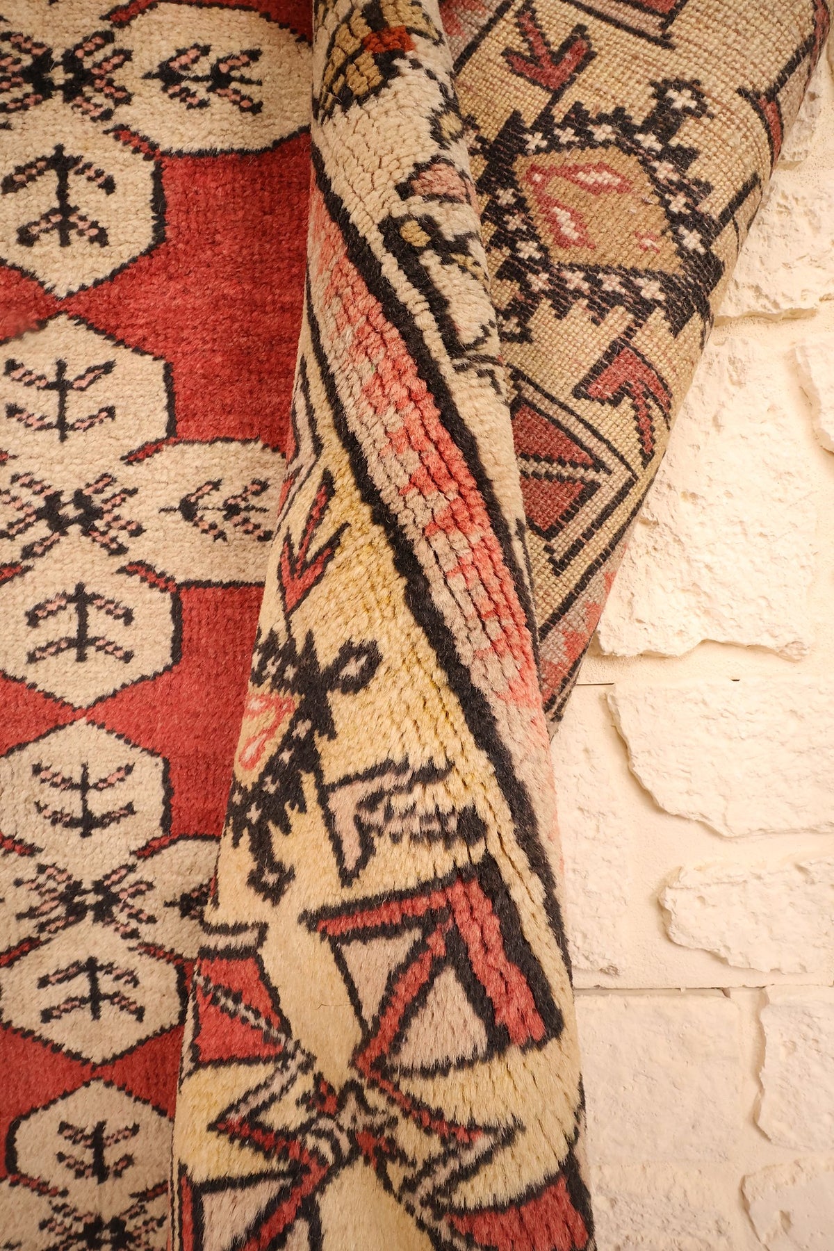 Tapis Melas rouge et noir, coin retourné laissant voir l'envers et les nœuds