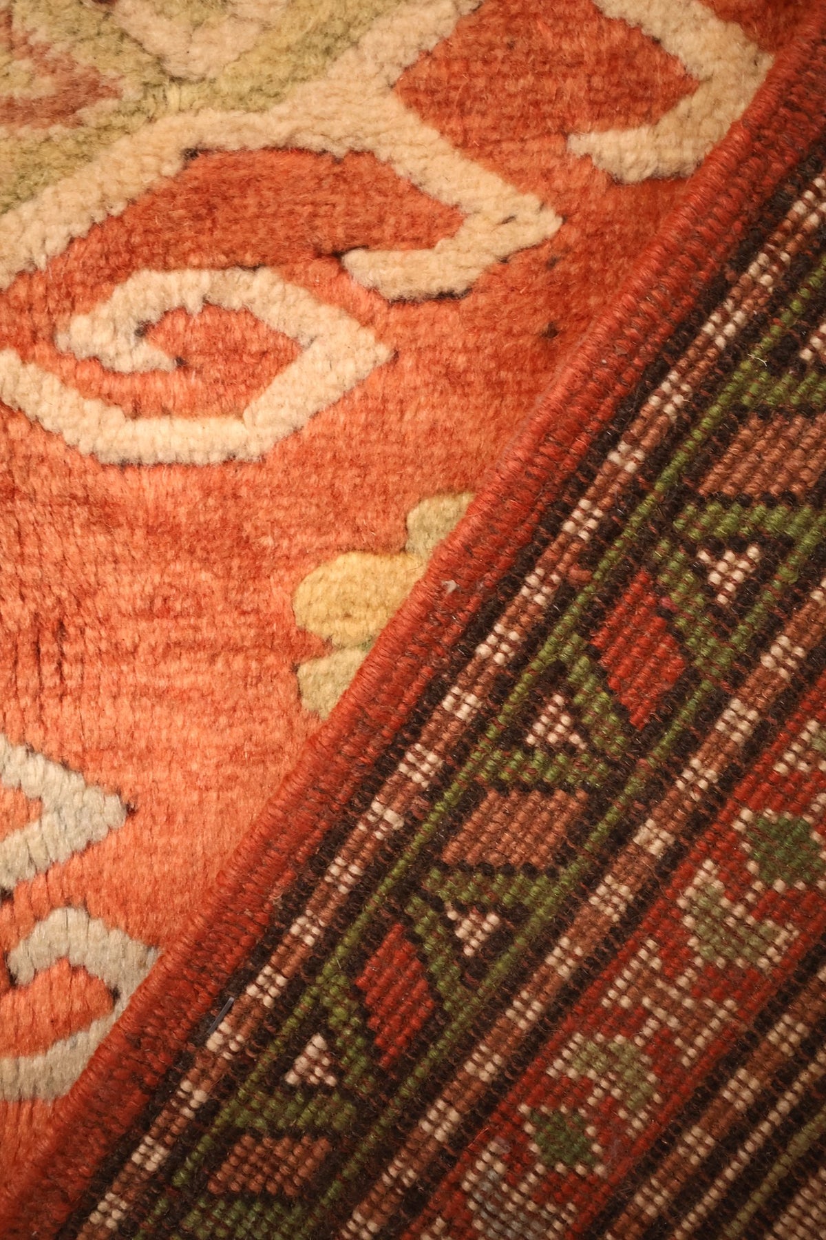 Envers du tapis Melas en laine, nœuds serrés visibles le long du bord