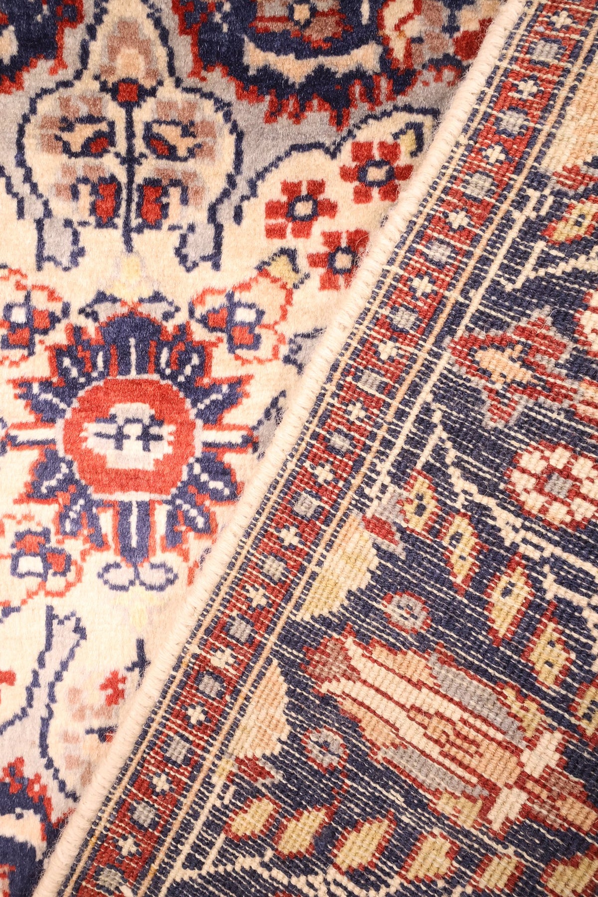 Coin replié du tapis Pendjab en laine, nœuds du décor floral visibles