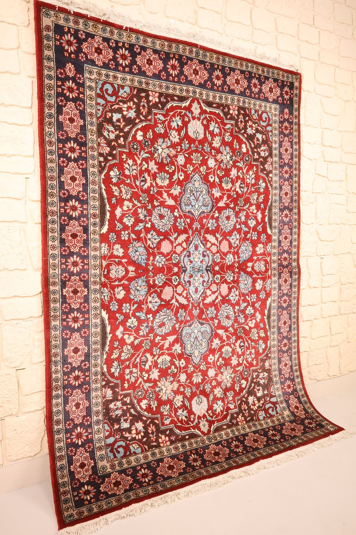 Tapis Pendjab rectangulaire rouge et bleu, vue de biais montrant les écoinçons bruns
