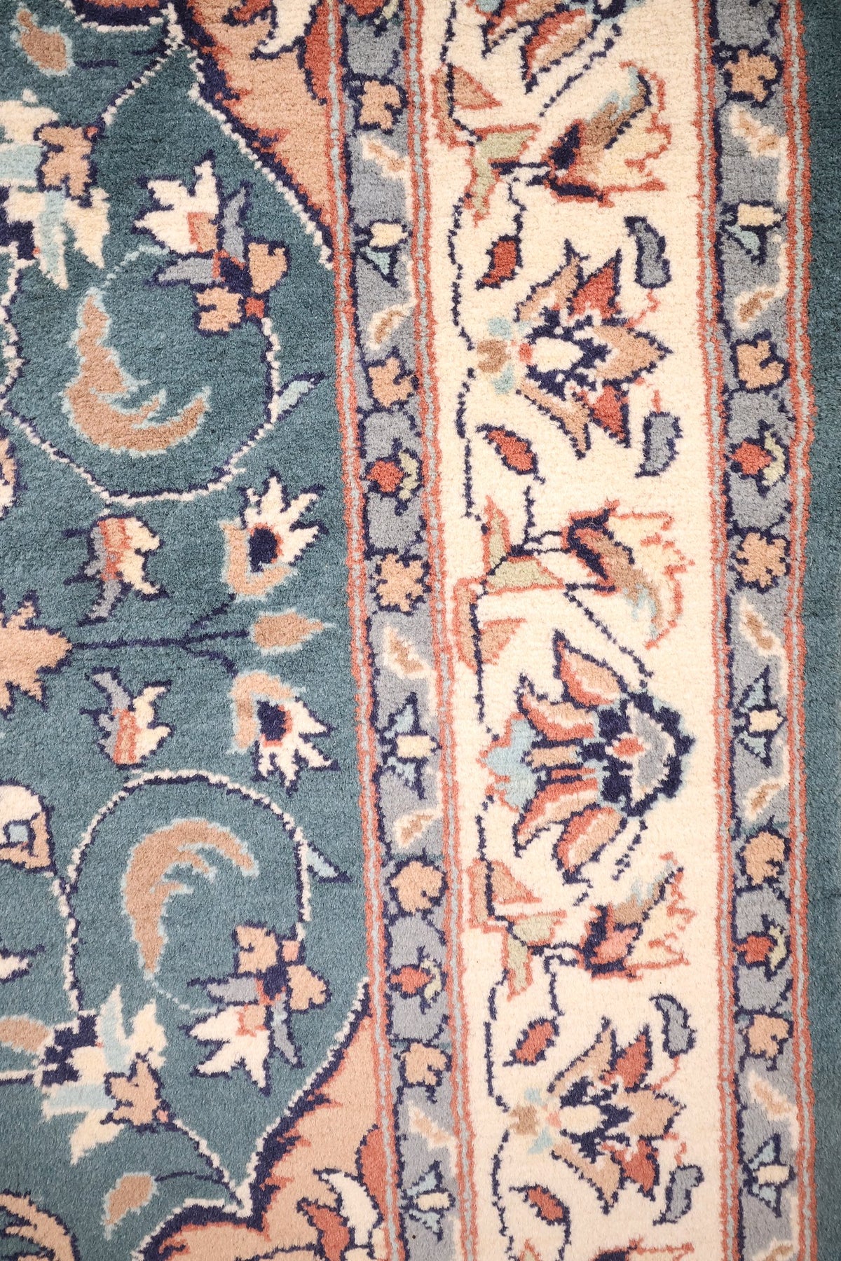 Bordure ivoire à guirlande florale et contre-bordures gris-bleu du tapis Pendjab