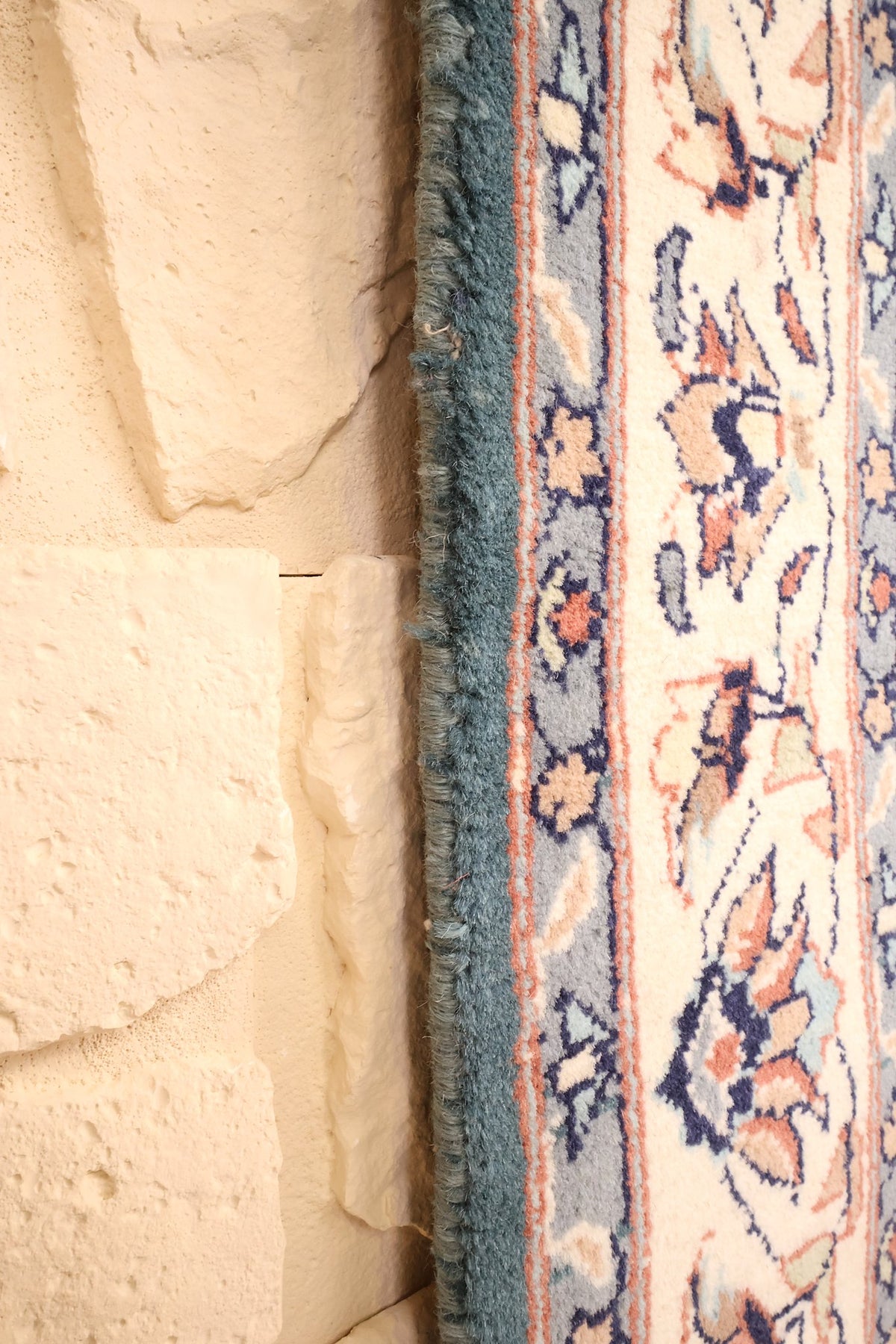 Lisière bleue du tapis Pendjab le long de la bordure ivoire à palmettes