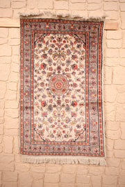 Tapis PLS beige 128 × 75 cm, vue d'ensemble du champ ivoire fleuri et des franges blanches