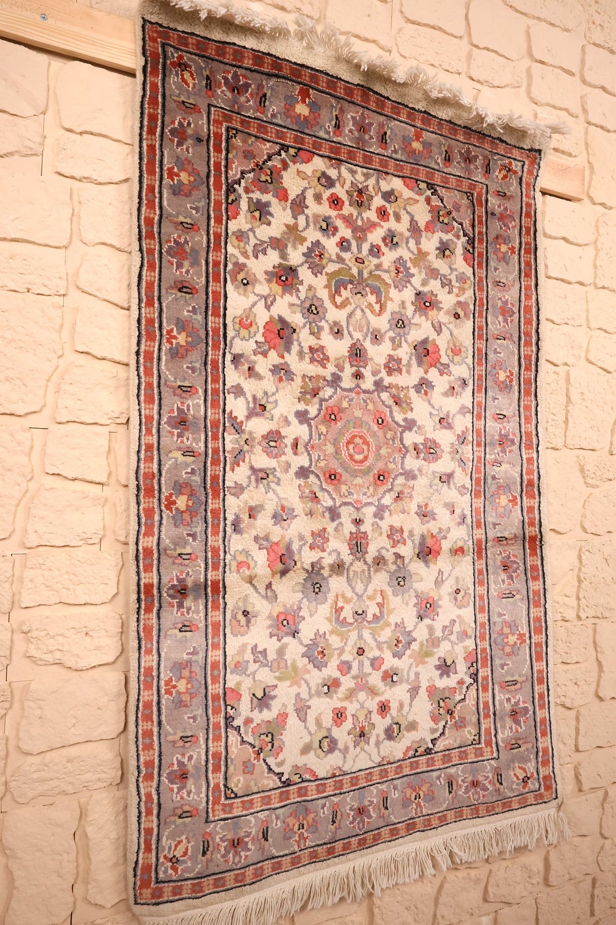 Tapis PLS beige et rouge vu de biais, bordure grise fleurie et contre-bordures à damiers