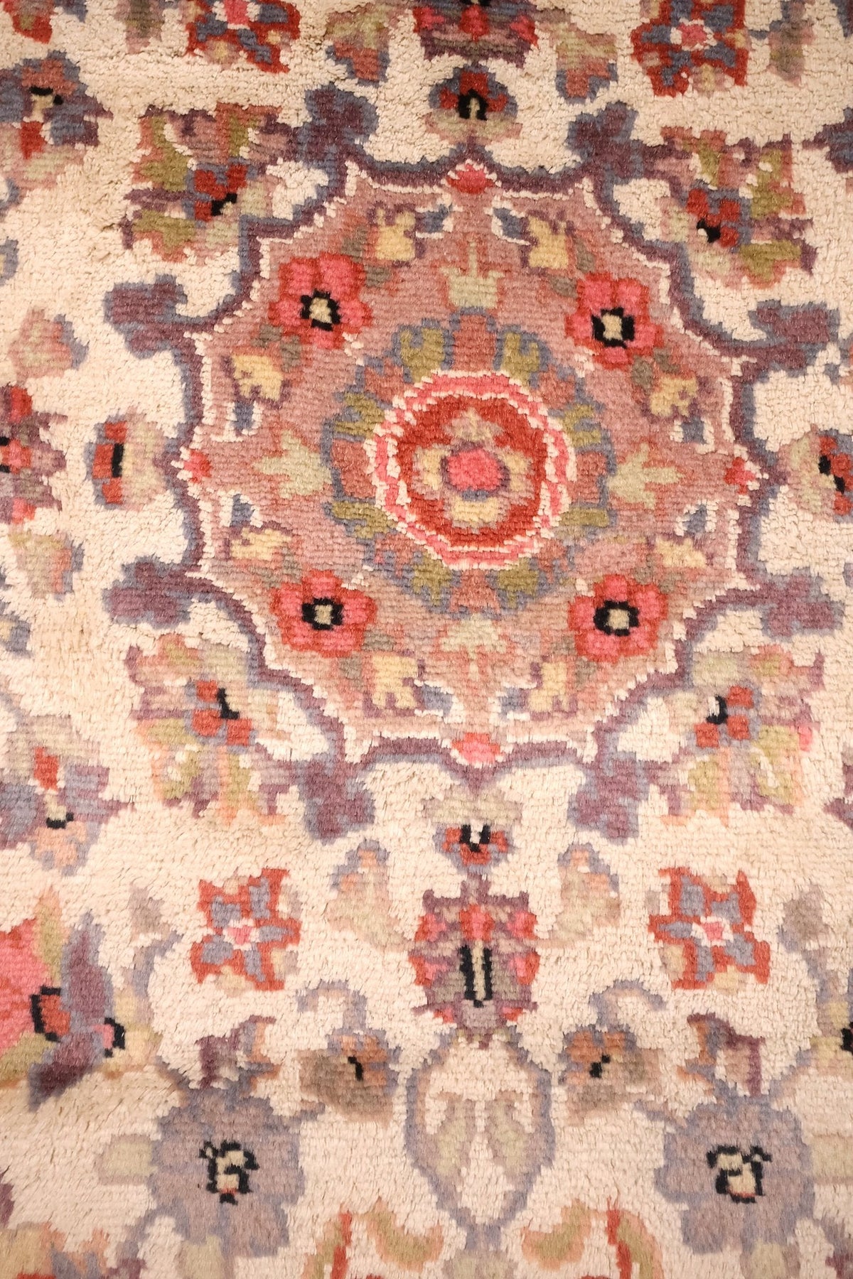 Détail du médaillon octogonal rose-mauve à rosace rouge et blanche du tapis PLS