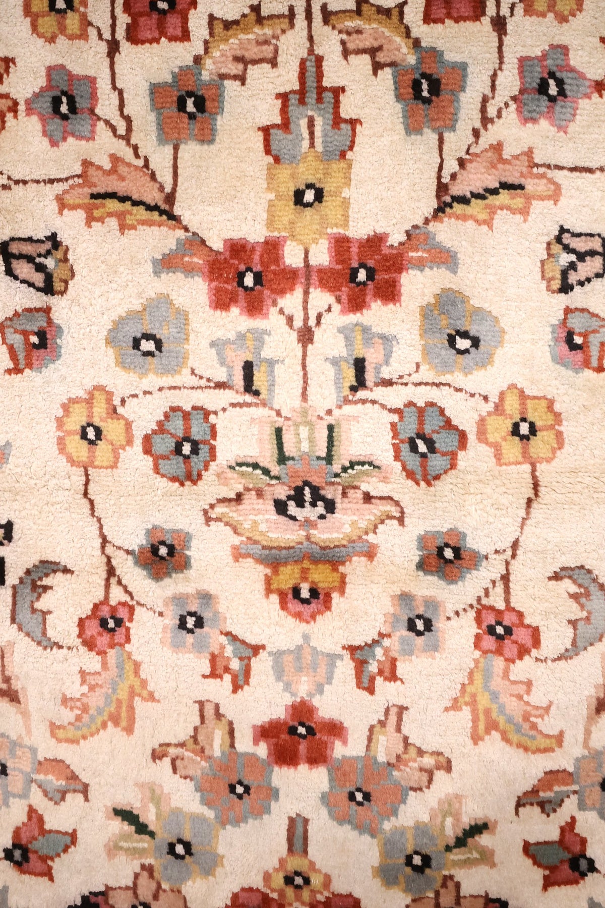 Détail du semis floral rouge, saumon et bleu-gris sur fond ivoire du tapis PLS
