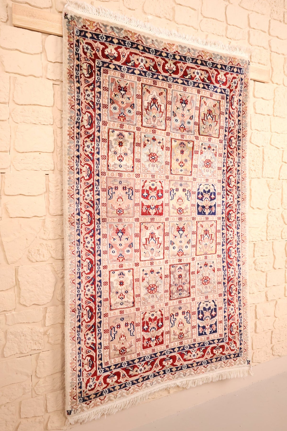 Tapis PLS beige, rouge et bleu vu de biais, franges claires aux deux extrémités