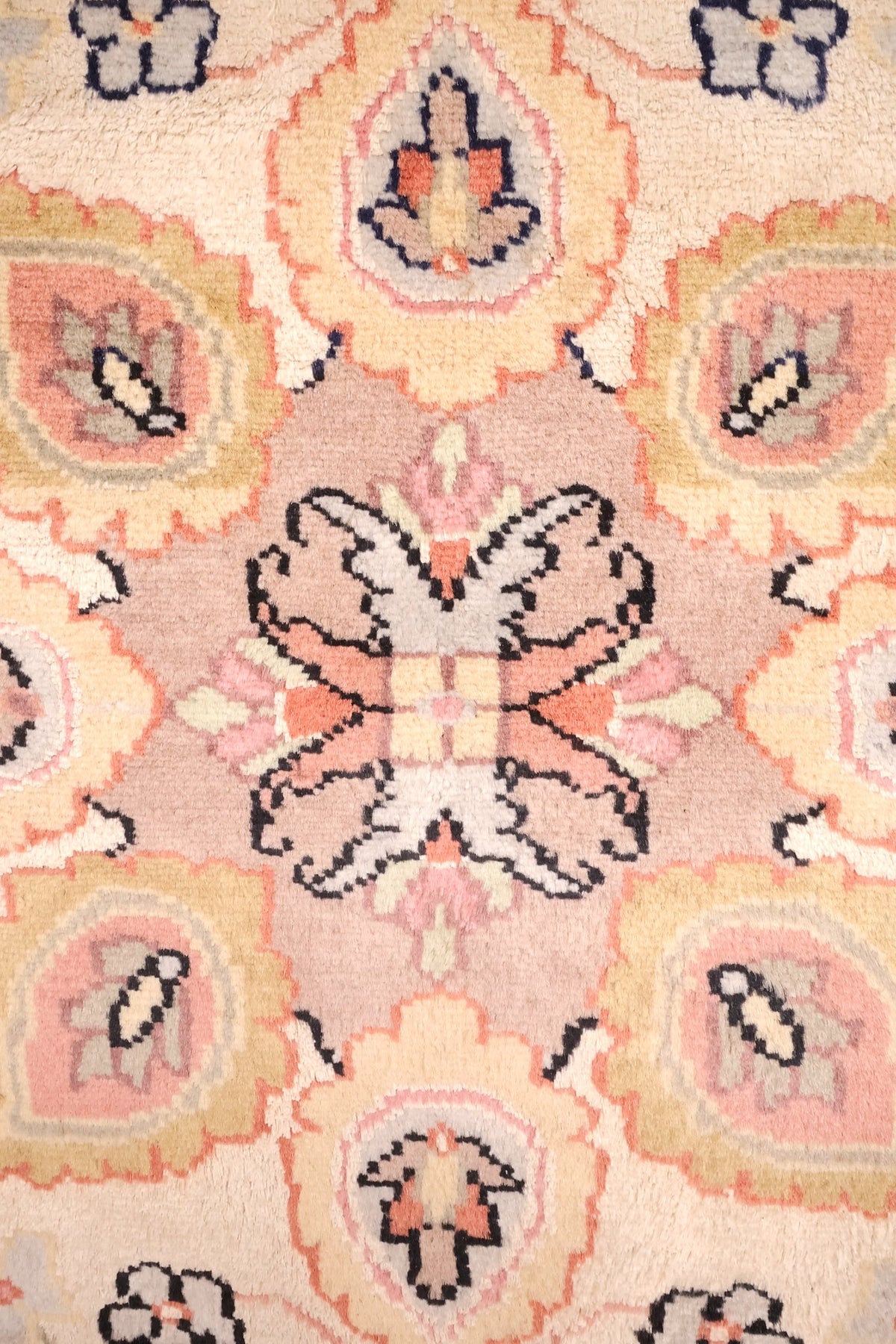 Détail du médaillon central rose-mauve à palmettes et rosaces du tapis PLS