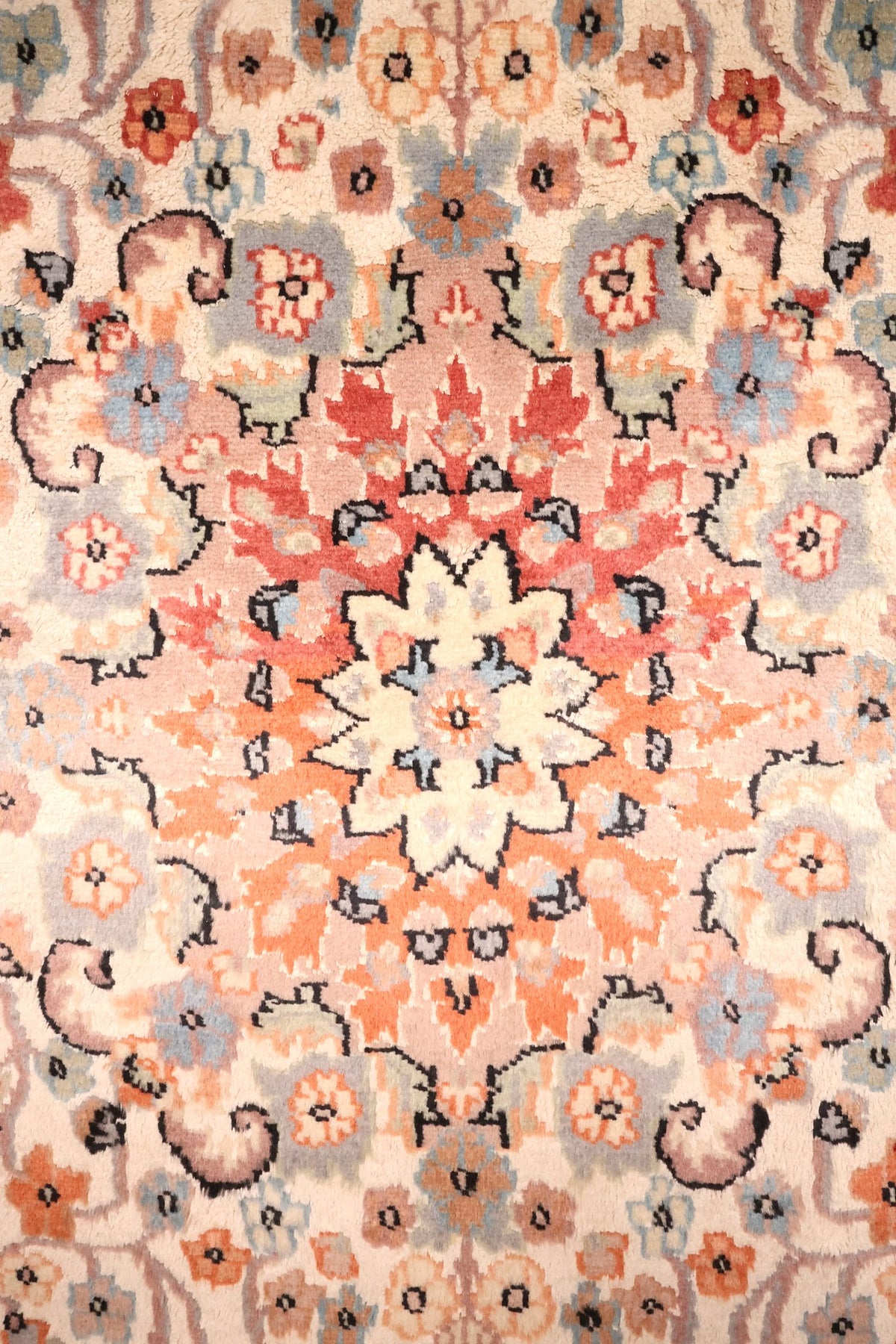 Détail du médaillon étoilé ivoire et des rayonnements orange du tapis PLS