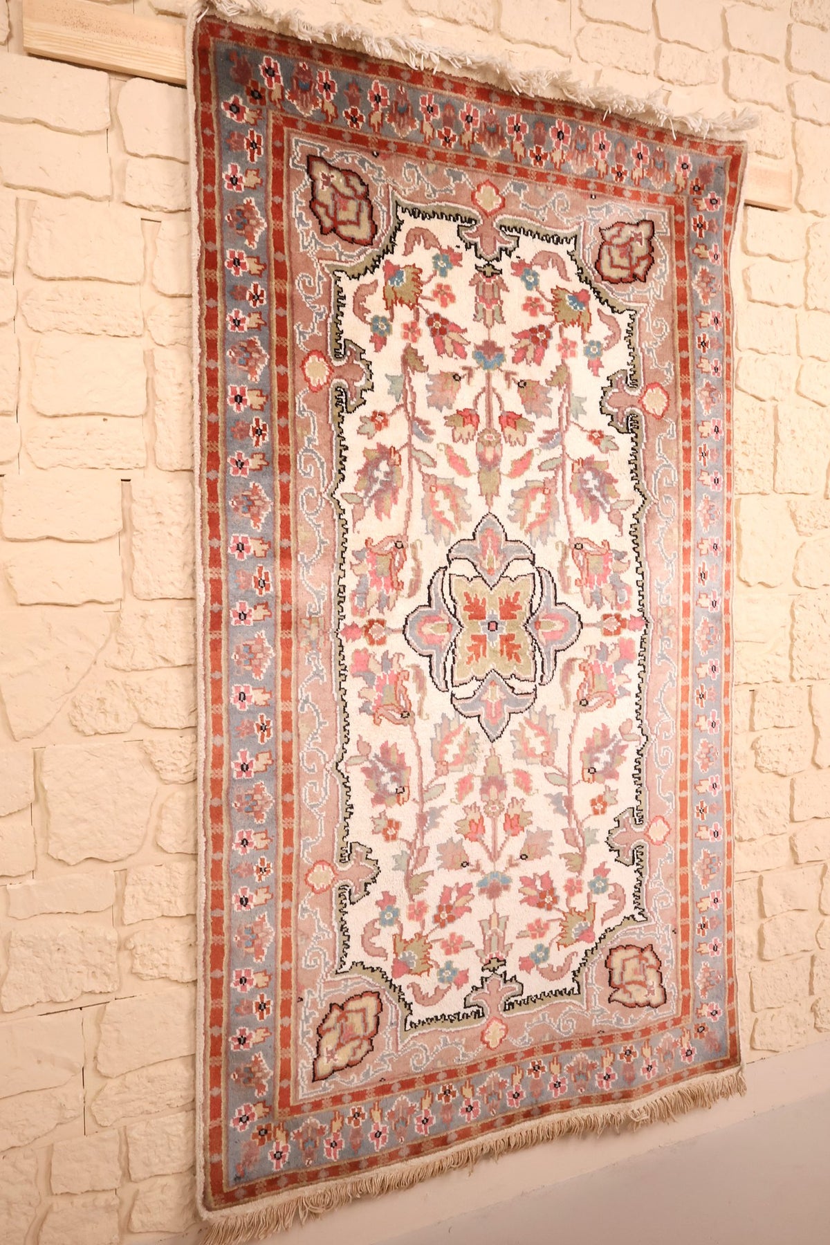 Tapis PLS rectangulaire en laine et soie artificielle, vue de biais sur le mur