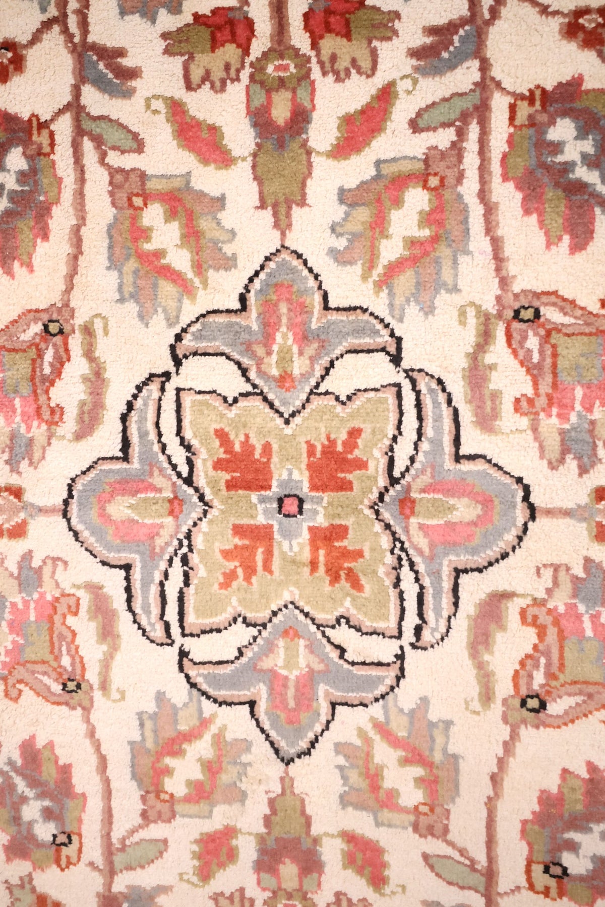 Détail du médaillon lobé cerné de noir et des palmettes roses du tapis PLS