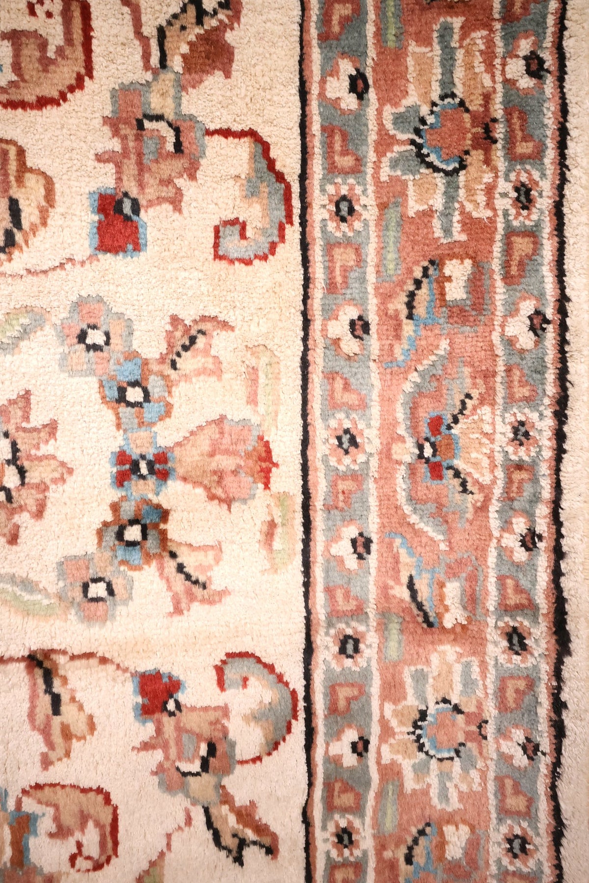 Bordure saumon à fleurons et filet noir du tapis PLS beige