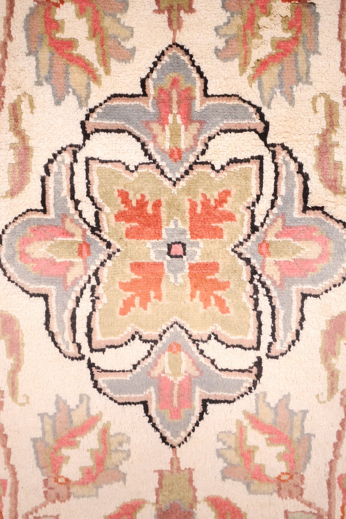 Détail du médaillon polylobé bleu-gris et vert olive à cœur orange du tapis PLS