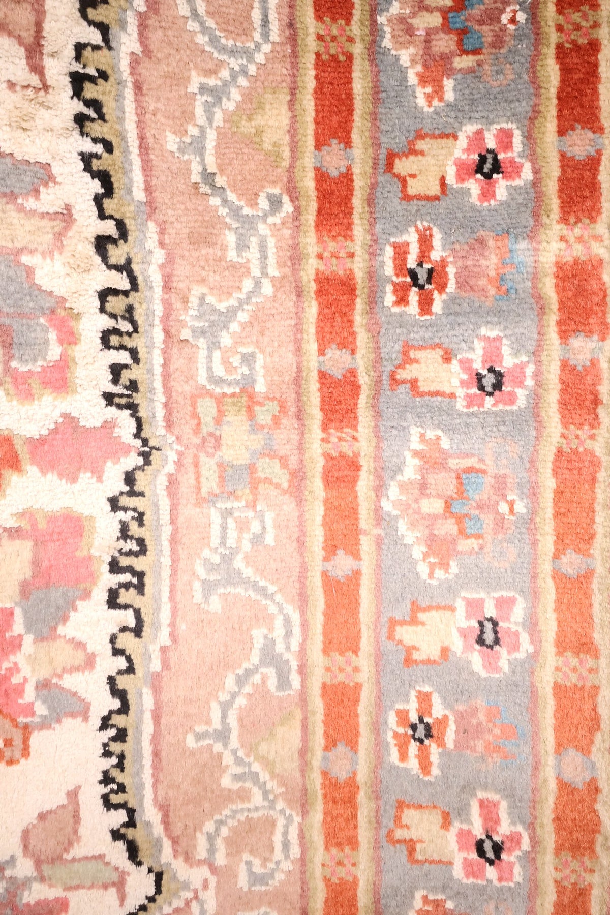 Bordures du tapis PLS : bande gris-bleu fleurie, bande rose à rinceaux et filets orange