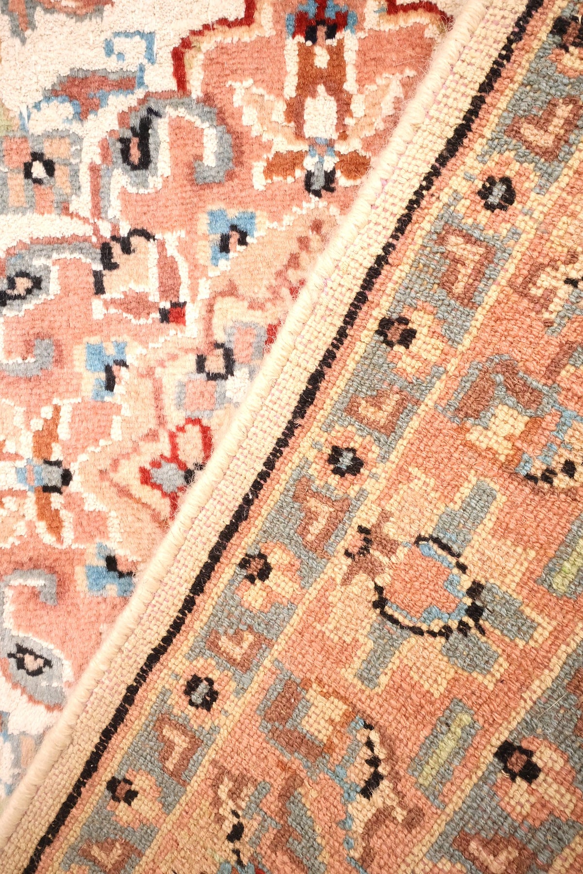 Envers du tapis PLS noué à la main, nœuds visibles côté bordure rose