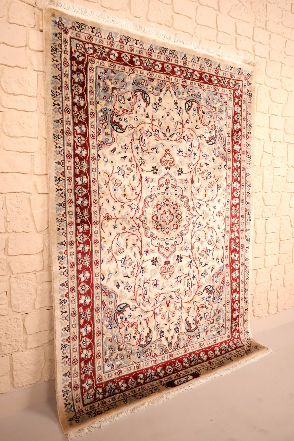 Tapis PLS beige et rouge en laine et soie artificielle, vue de biais avec franges