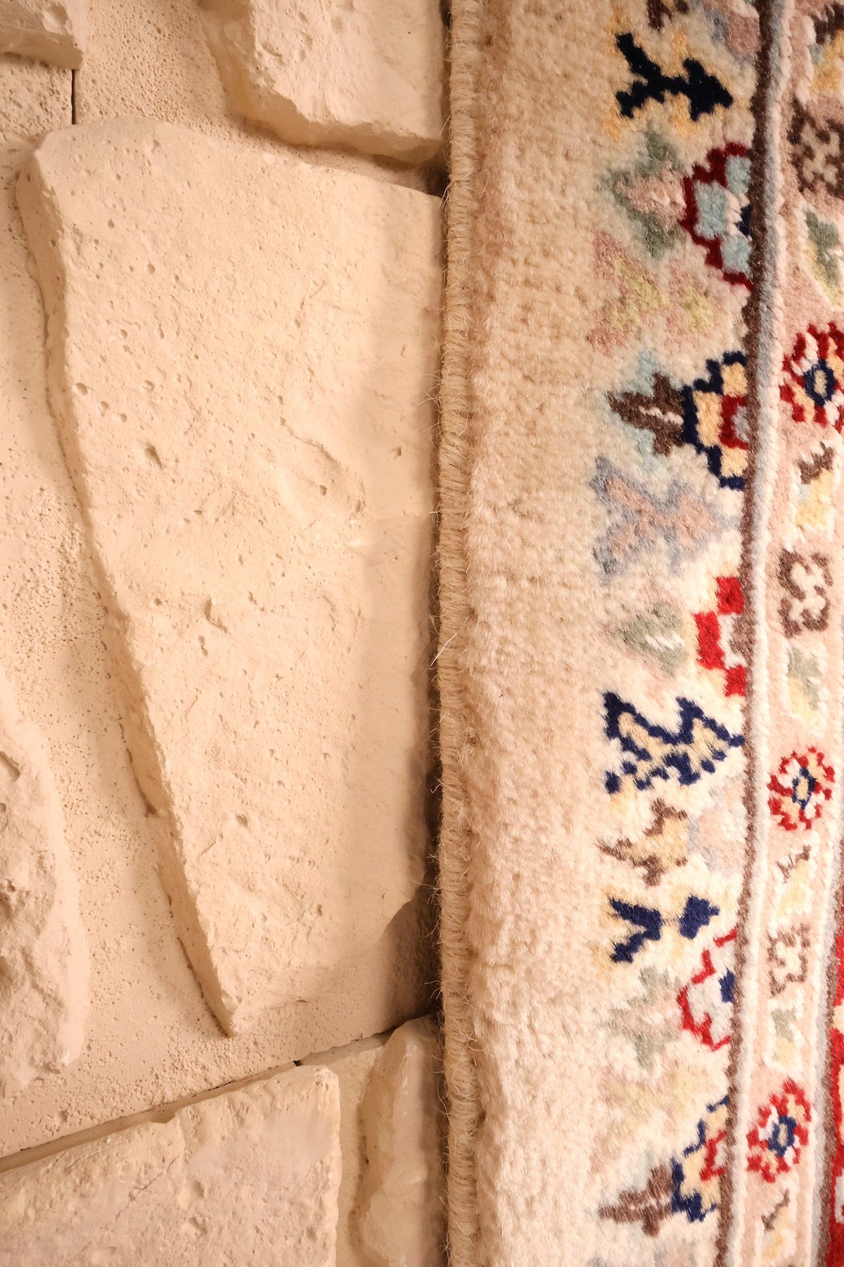 Lisière du tapis PLS beige le long de la contre-bordure crème à fleurs bleues